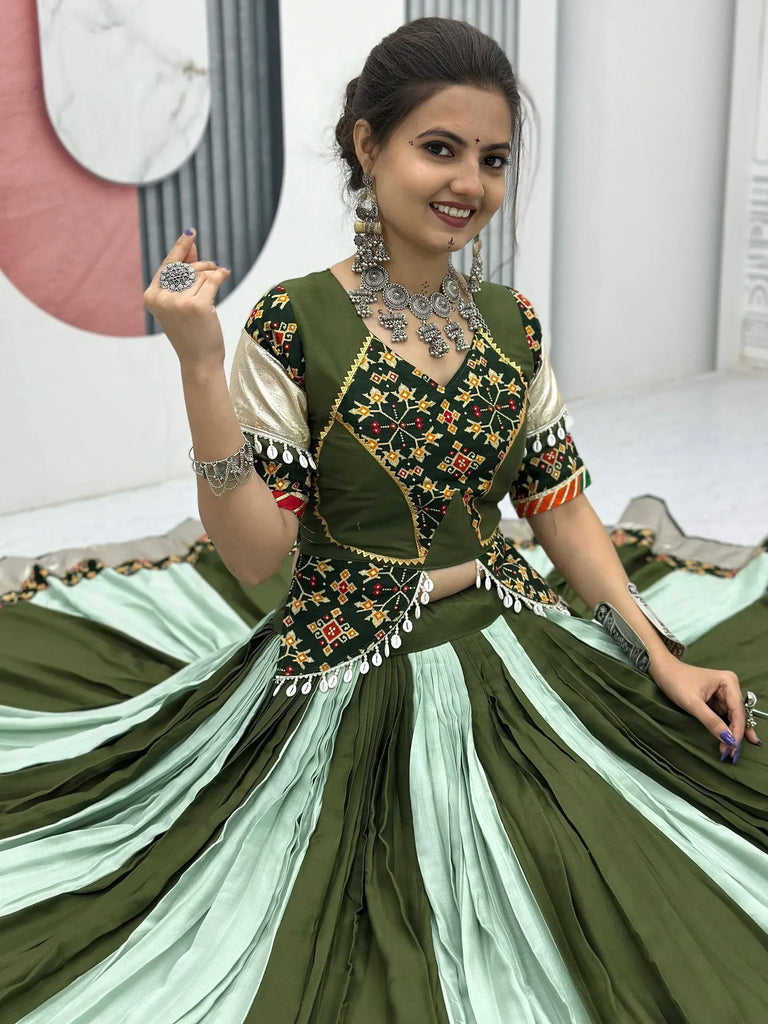 Woman in olive green embroidered lehenga choli with silver jewelry, showcasing Indian ethnic wear