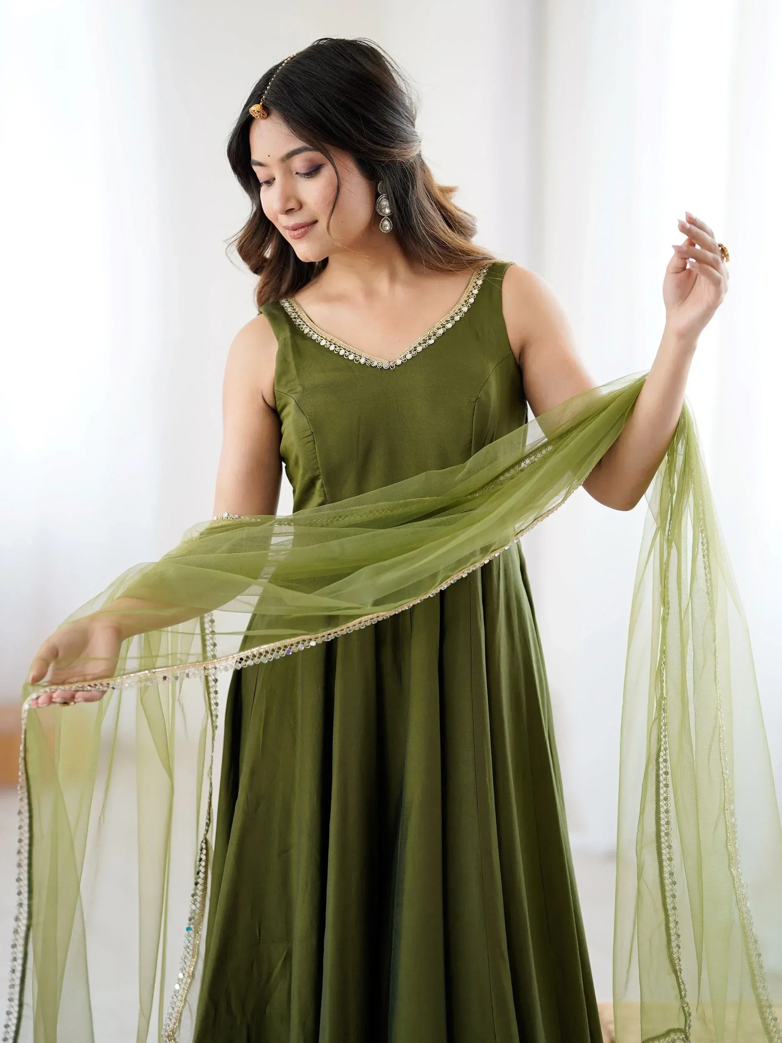 Olive green ethnic gown with gold embroidery and sheer dupatta, perfect for Indian occasions