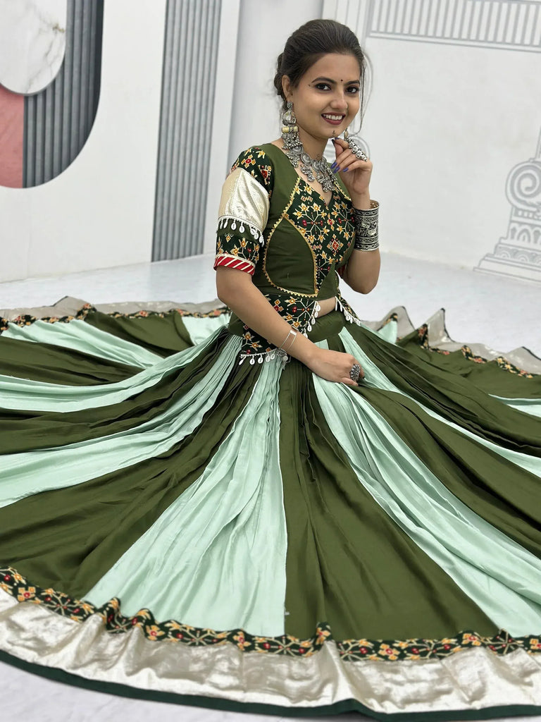 Woman in olive green and mint lehenga choli with intricate embroidery and traditional jewelry