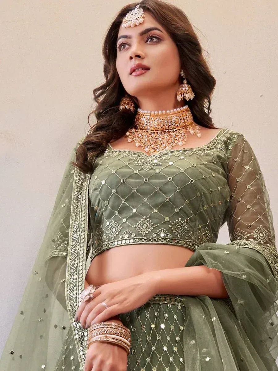 Olive green designer lehenga choli with intricate embroidery and matching jewelry for Indian ethnic wear