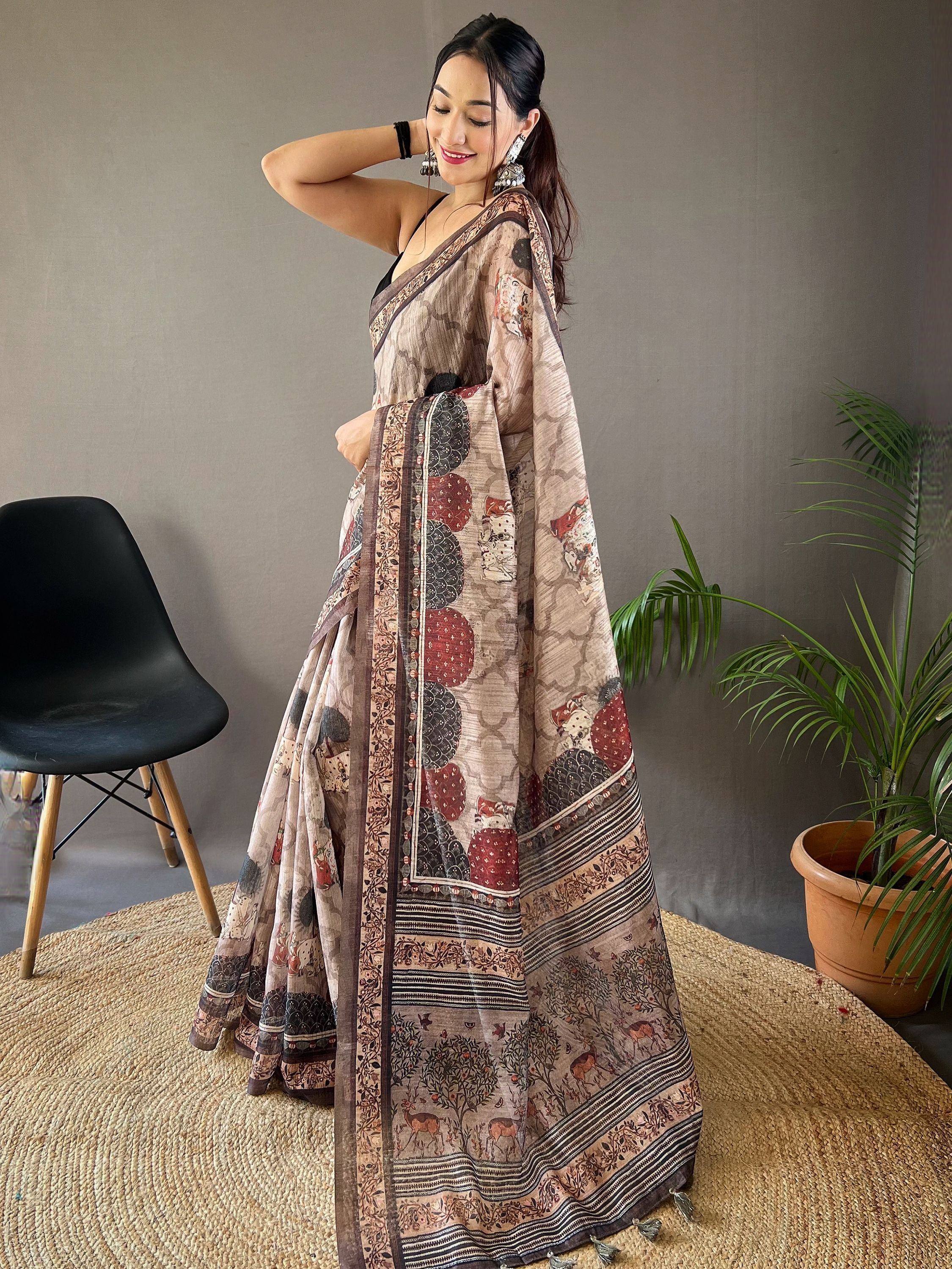 Woman in printed ethnic saree with deer and floral motifs, styled with black blouse and statement earrings