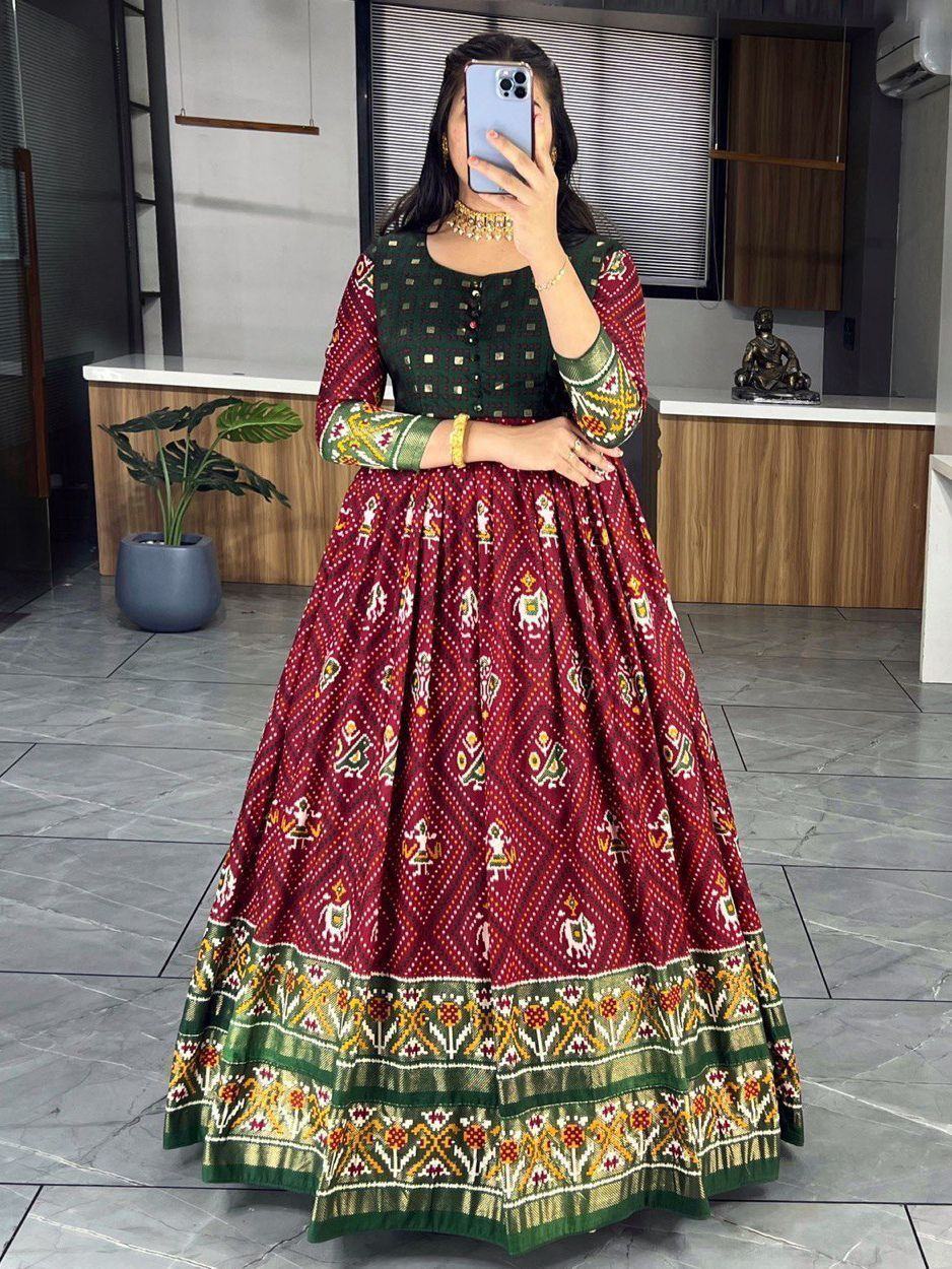 Woman wearing maroon and green traditional ethnic gown with printed patterns indoors