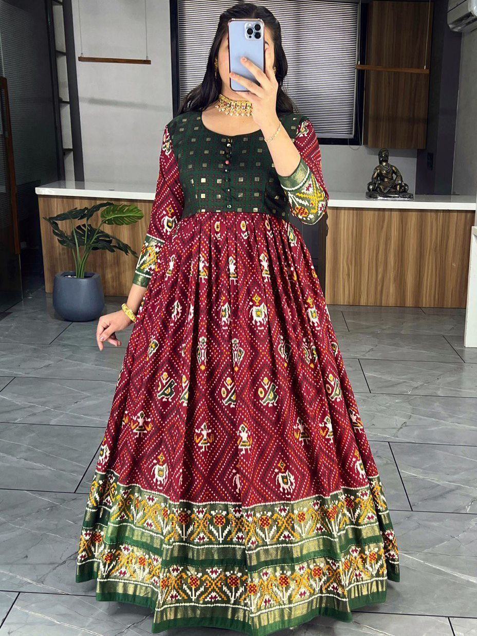 Woman wearing maroon and green long ethnic gown with traditional Indian prints