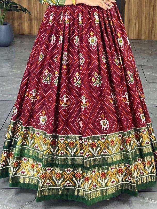 Maroon ethnic lehenga skirt with intricate folk motifs and green border, perfect for Indian weddings and festivals