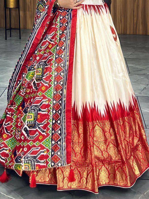 Ethnic lehenga choli with vibrant red and green elephant print, gold border, and tassels