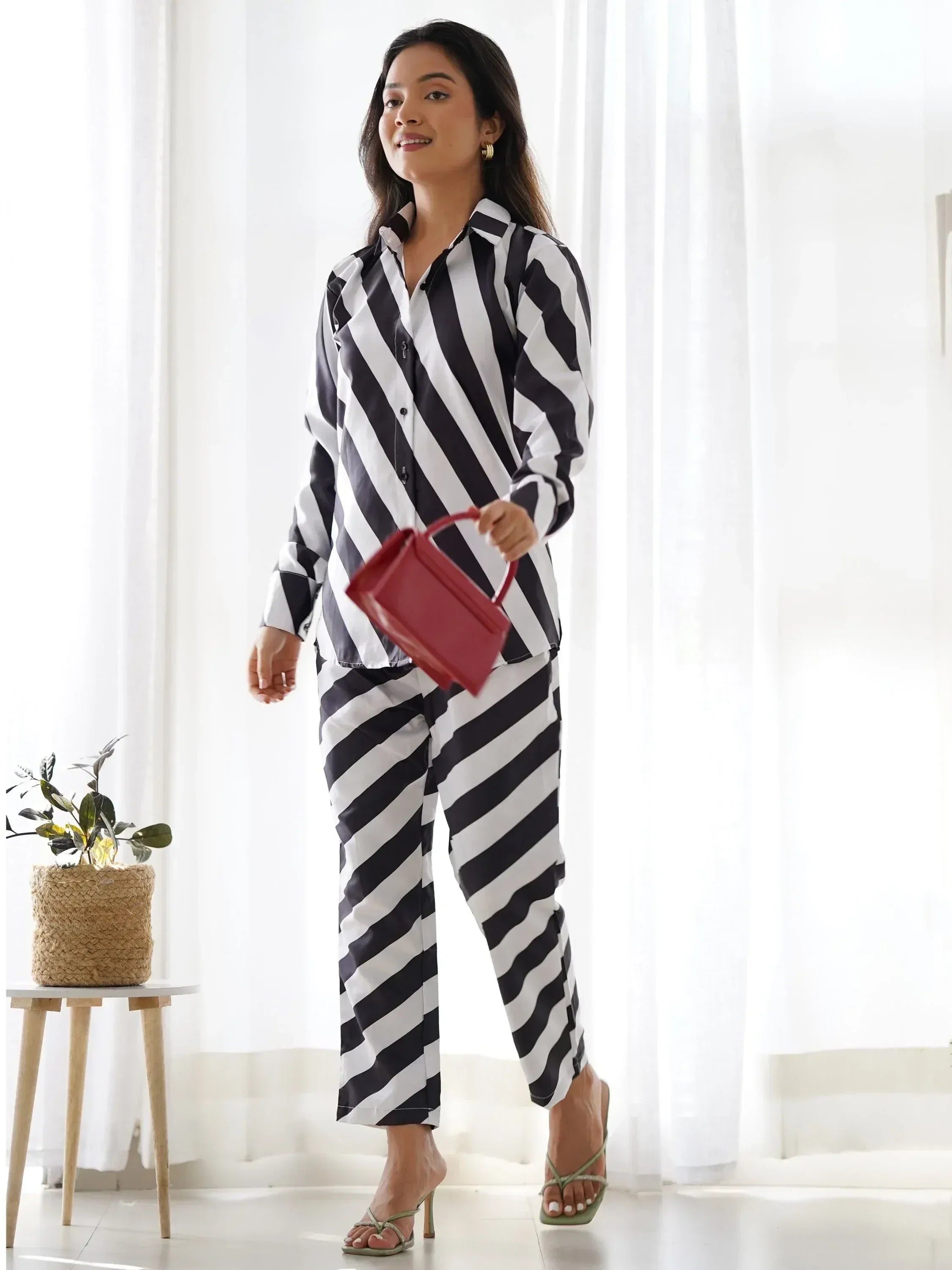Woman in black and white striped pajama set with red handbag, stylish loungewear for women