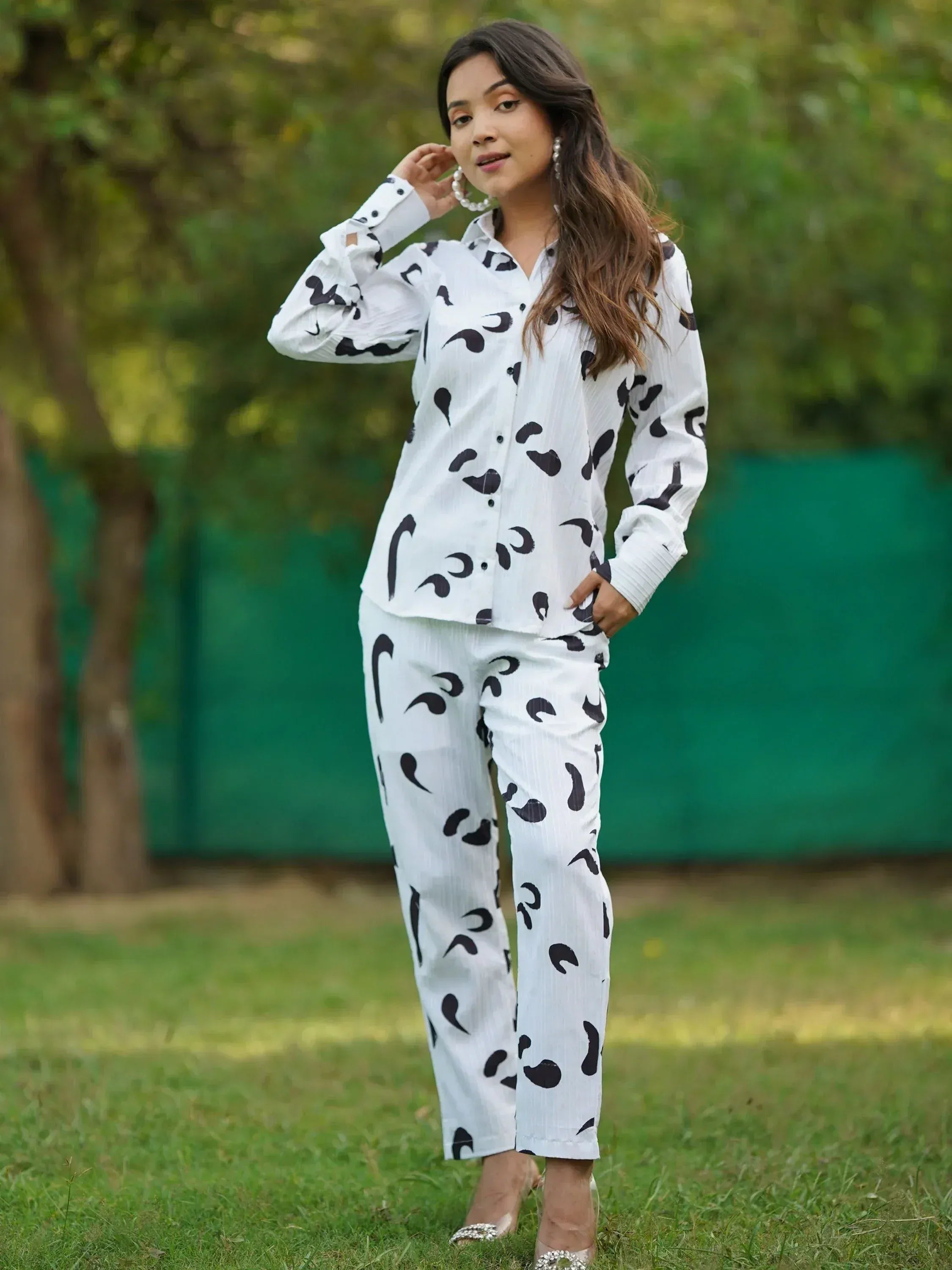 Woman in white black abstract print shirt pants set, ethnic wear, outdoor garden setting