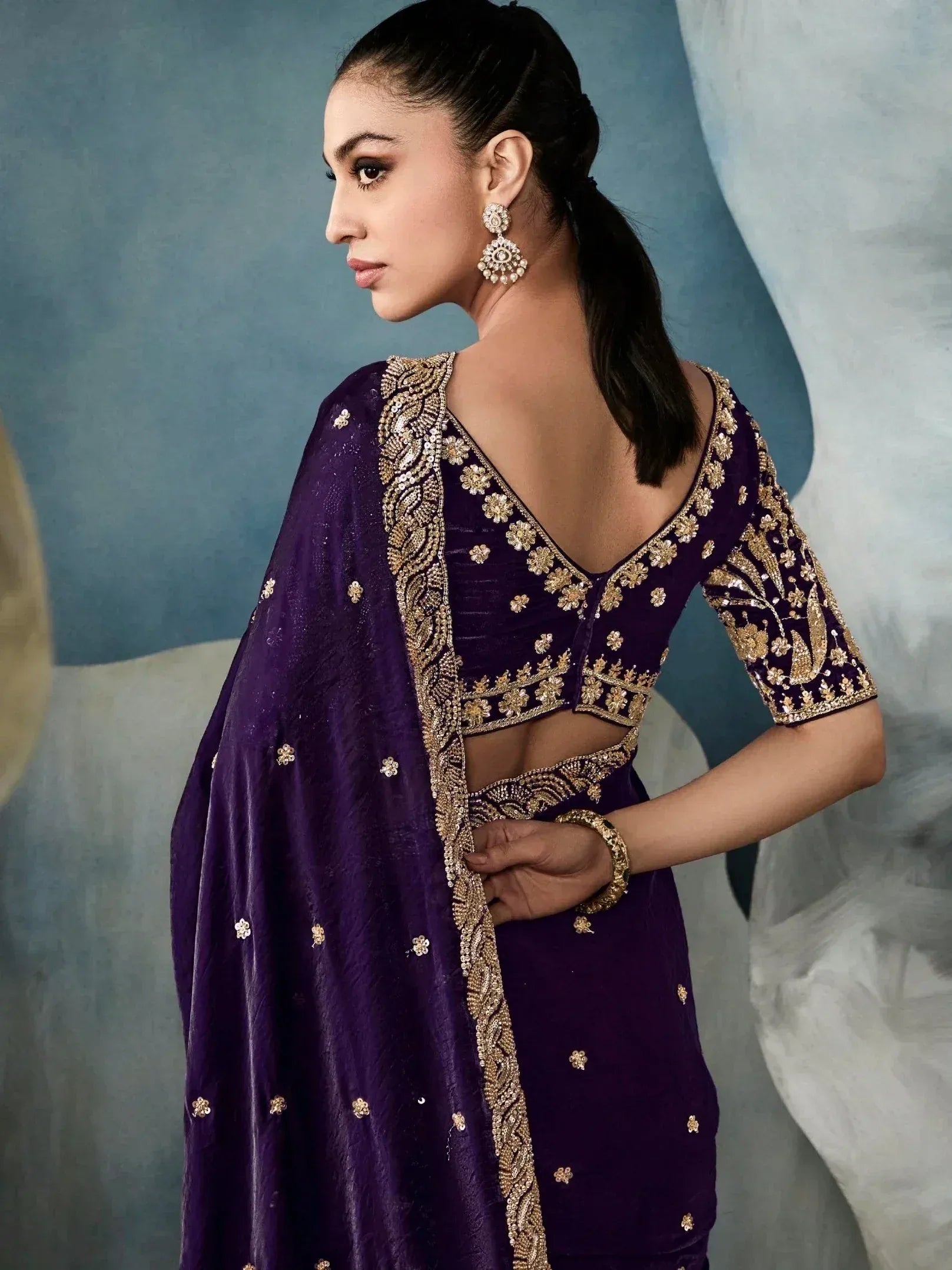 Purple velvet ethnic gown with gold embroidery, backless design, and matching dupatta for Indian occasions