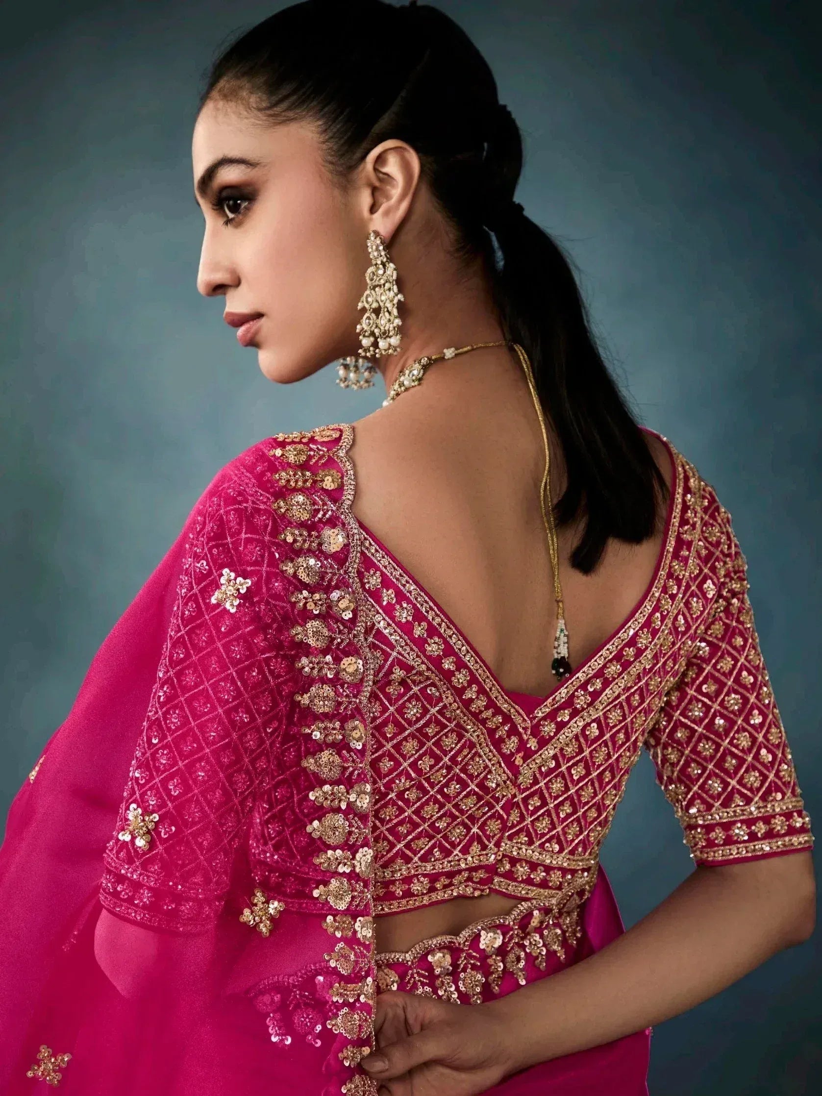 Pink designer lehenga choli with gold embroidery and backless blouse, perfect for Indian ethnic wear occasions.