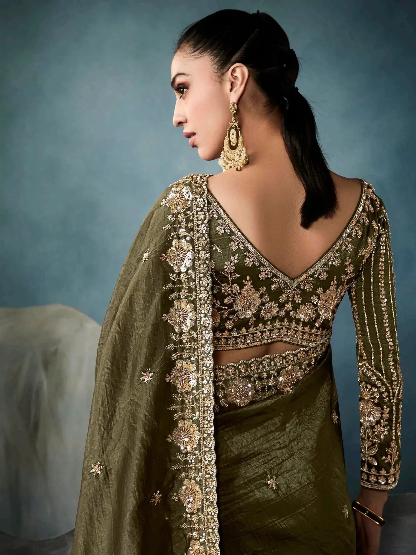 Olive green designer lehenga choli with gold embroidery and backless blouse, perfect for Indian ethnic wear events.