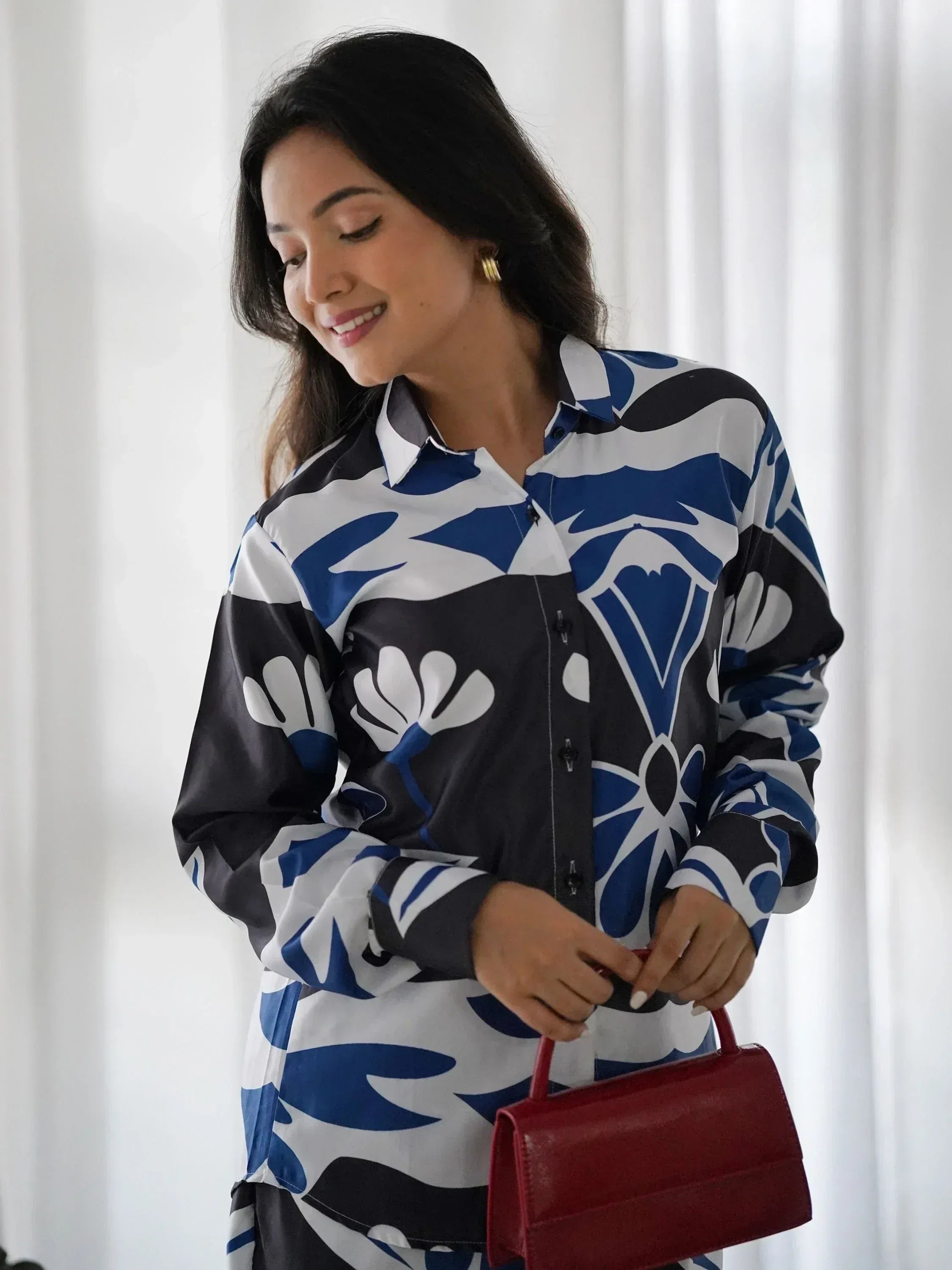 Woman in blue and white floral print shirt with red handbag, stylish ethnic wear