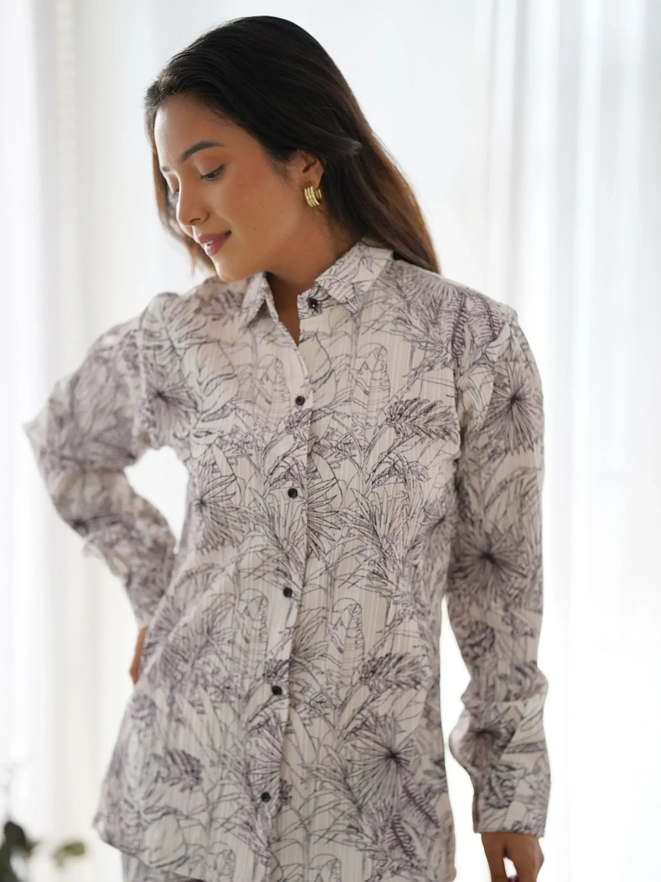 Woman wearing floral print ethnic shirt with button front and long sleeves, ideal for casual or semi-formal wear