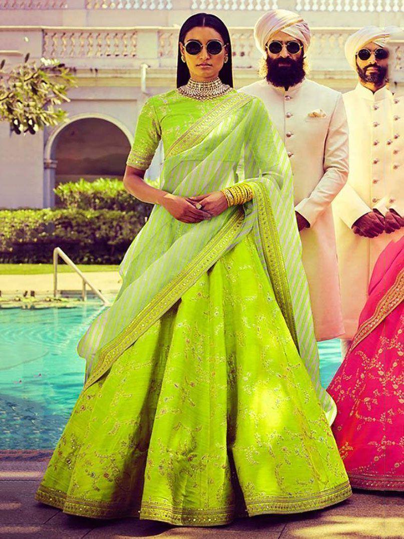 Vibrant green designer lehenga choli with gold embroidery, perfect for Indian weddings and festive occasions.