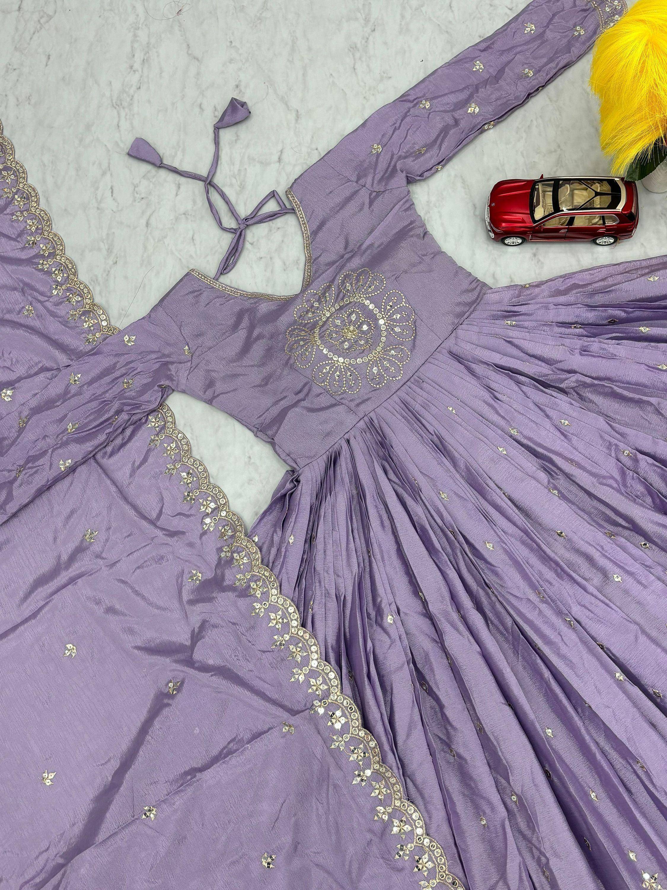 Lavender ethnic gown with gold embroidery, mirror work, and tie-back neckline, perfect for Indian occasions.