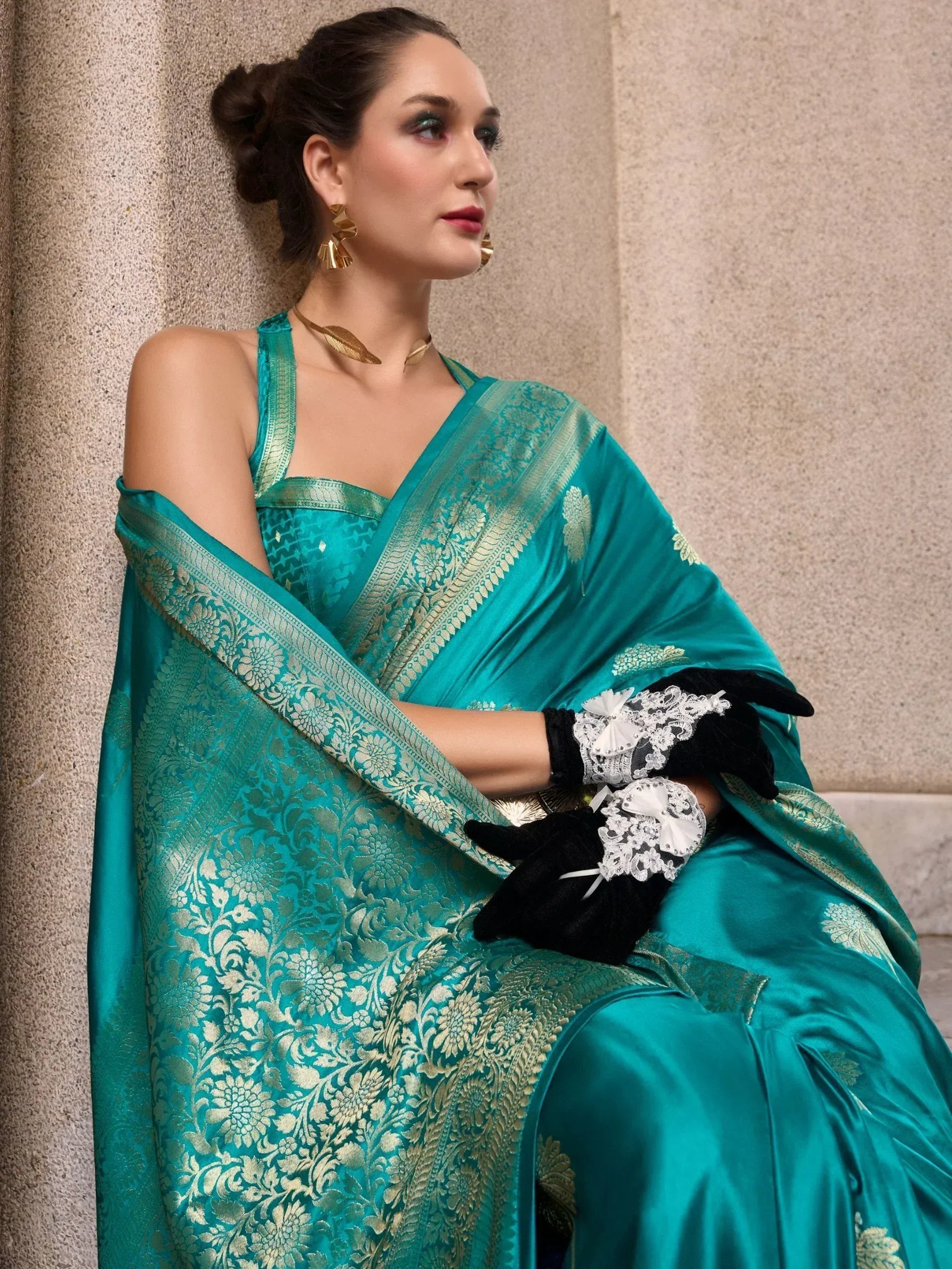 Teal designer saree with gold floral embroidery, black lace gloves, and gold jewelry for ethnic wear