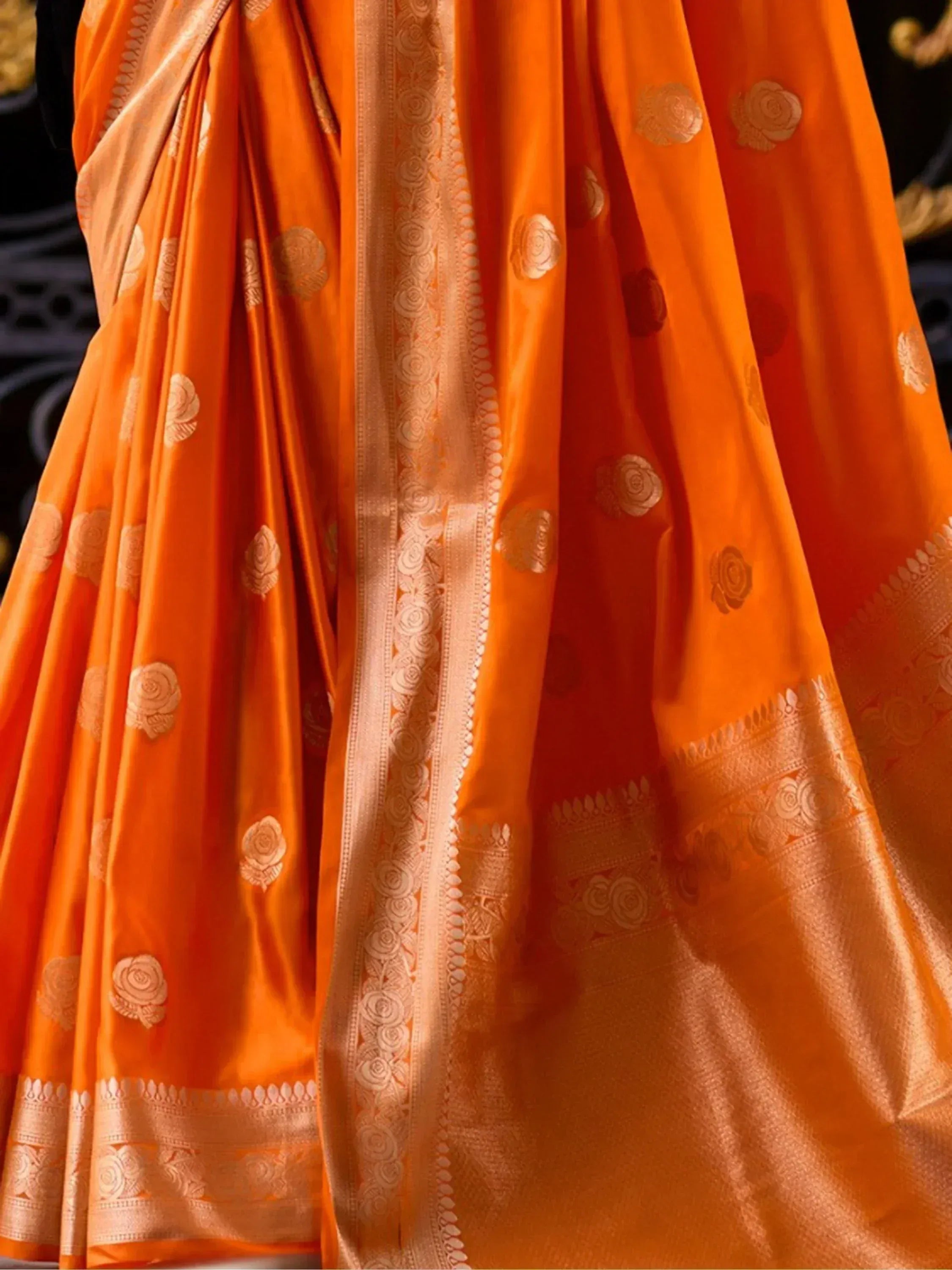 Vibrant orange silk saree with gold floral motifs and intricate border, ideal for Indian ethnic occasions.