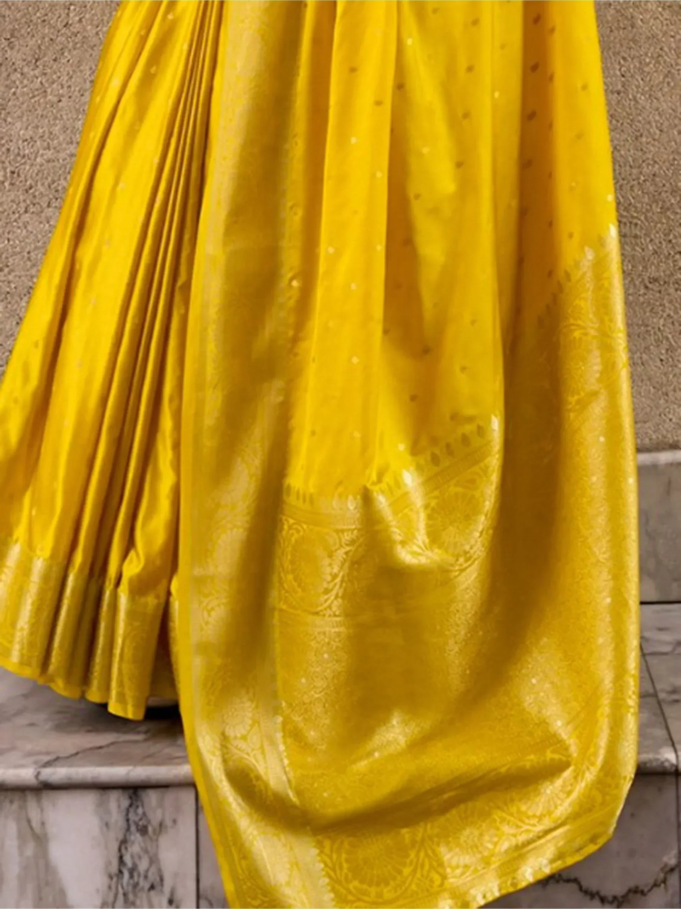 Vibrant yellow ethnic saree with intricate gold embroidery and pleated design, perfect for festive occasions.