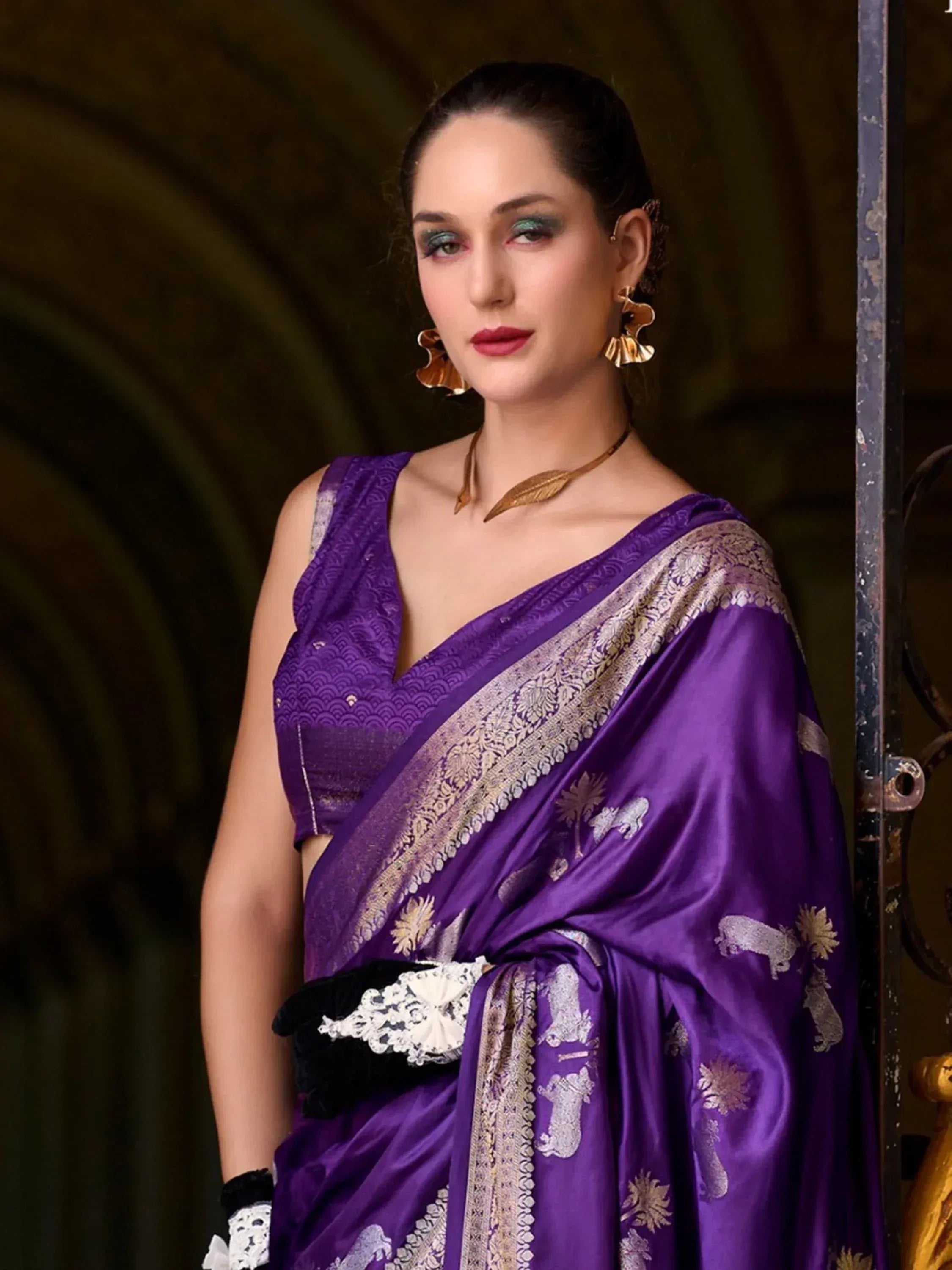 Purple designer saree with gold elephant motifs and lace border, styled with statement jewelry for ethnic occasions