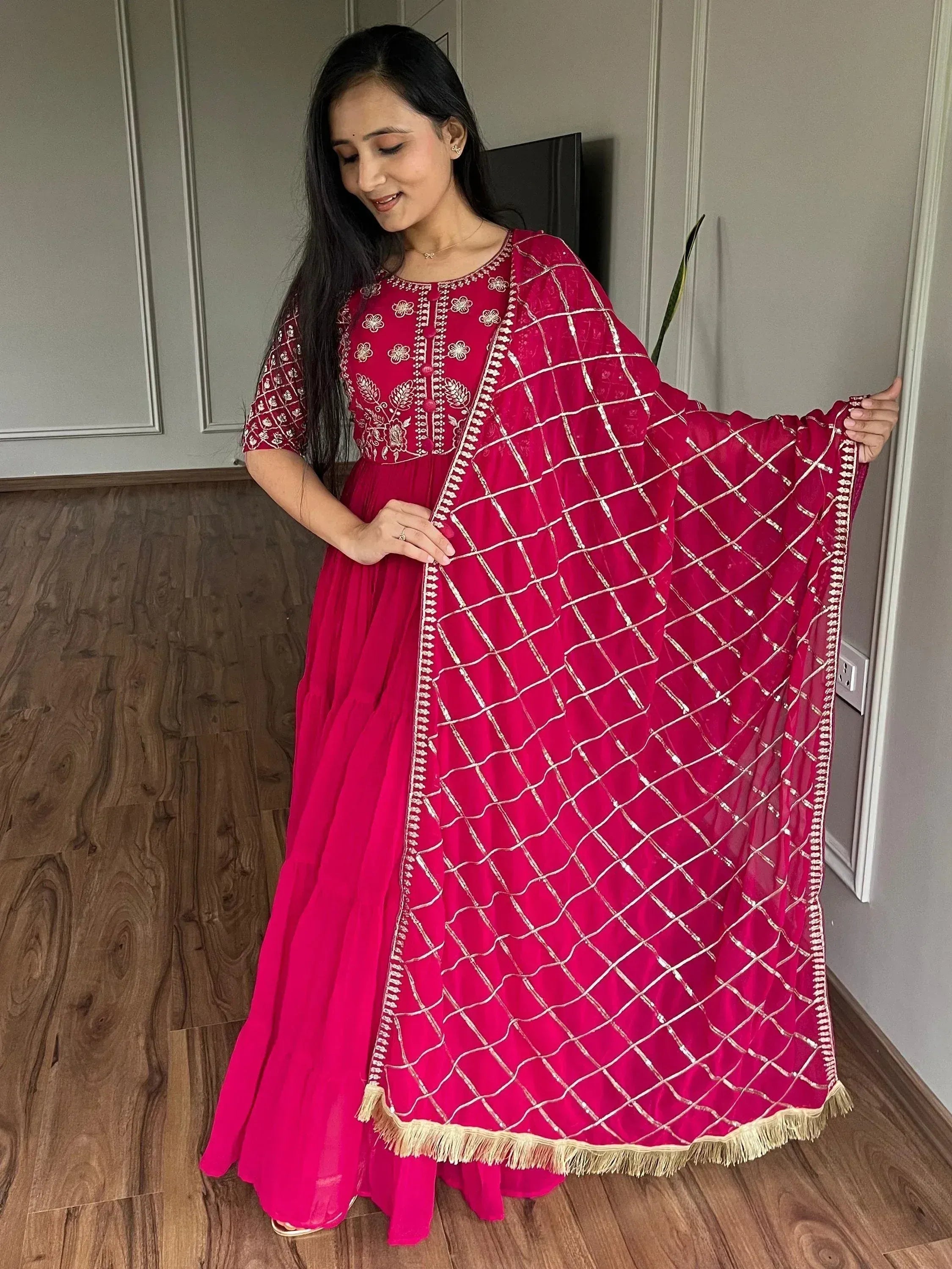 Fuchsia ethnic gown with gold embroidery and net dupatta, perfect for Indian occasions