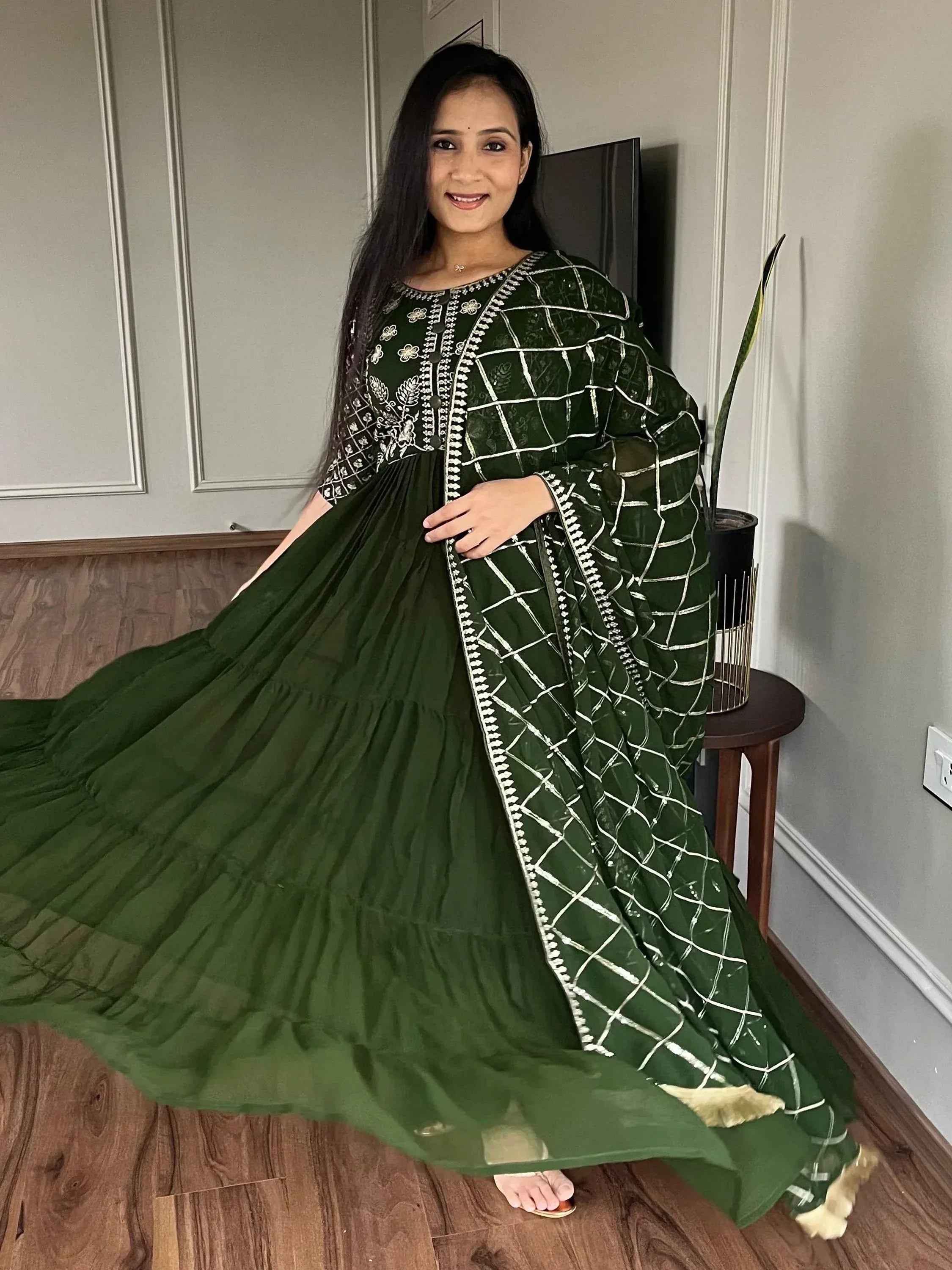 Elegant green ethnic gown with white embroidery and tiered skirt, perfect for festive occasions.