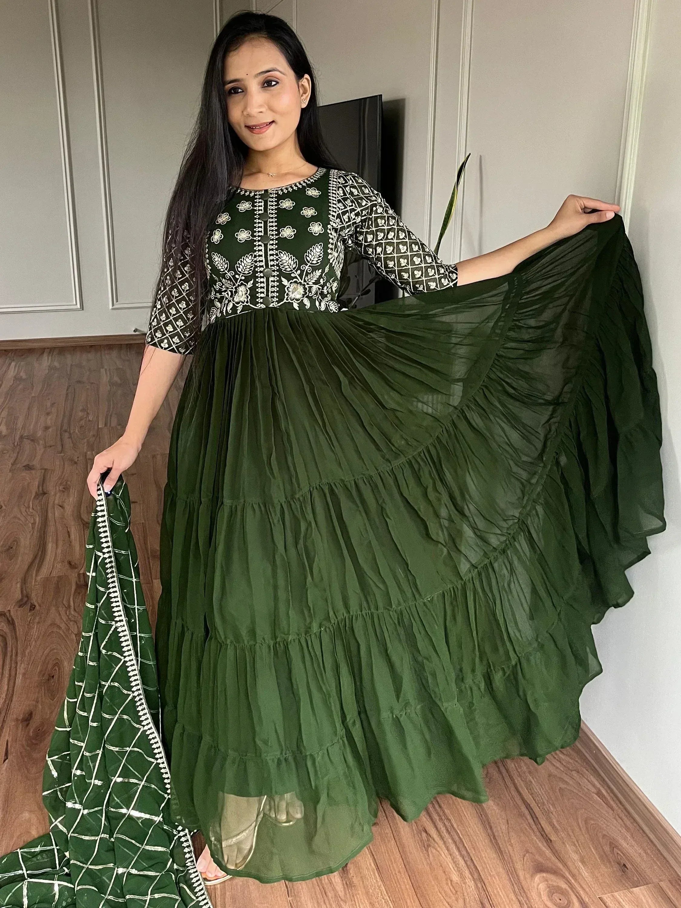 Green embroidered ethnic gown with tiered ruffle skirt and matching dupatta, ideal for Indian wear