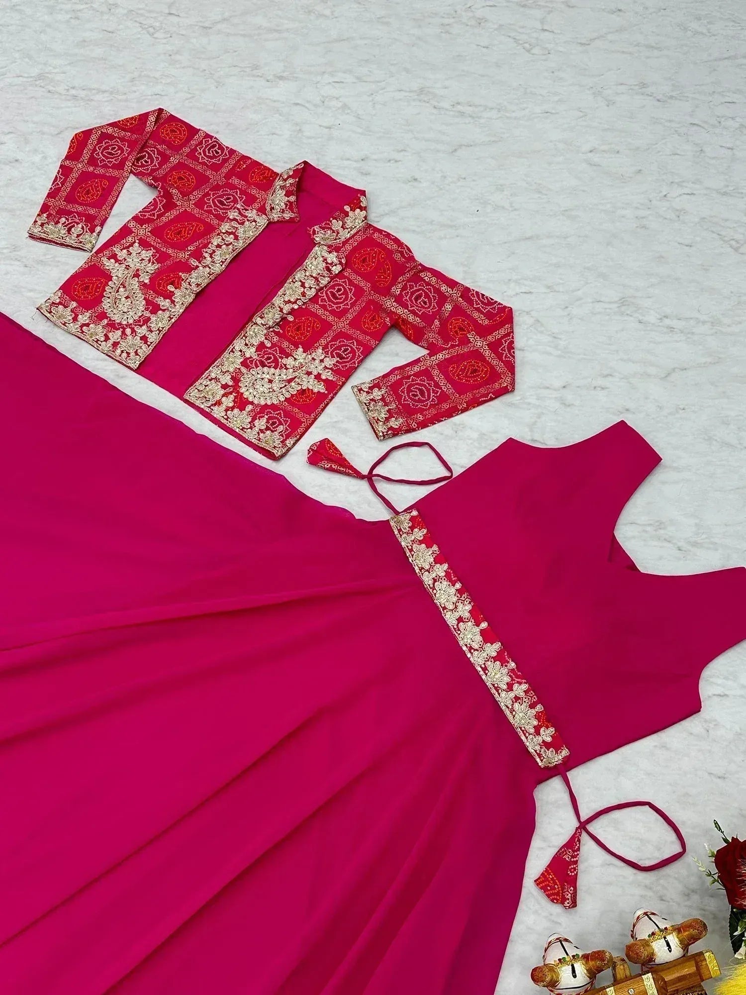 Fuchsia ethnic gown with red embroidered jacket, perfect for Indian celebrations and festive occasions.