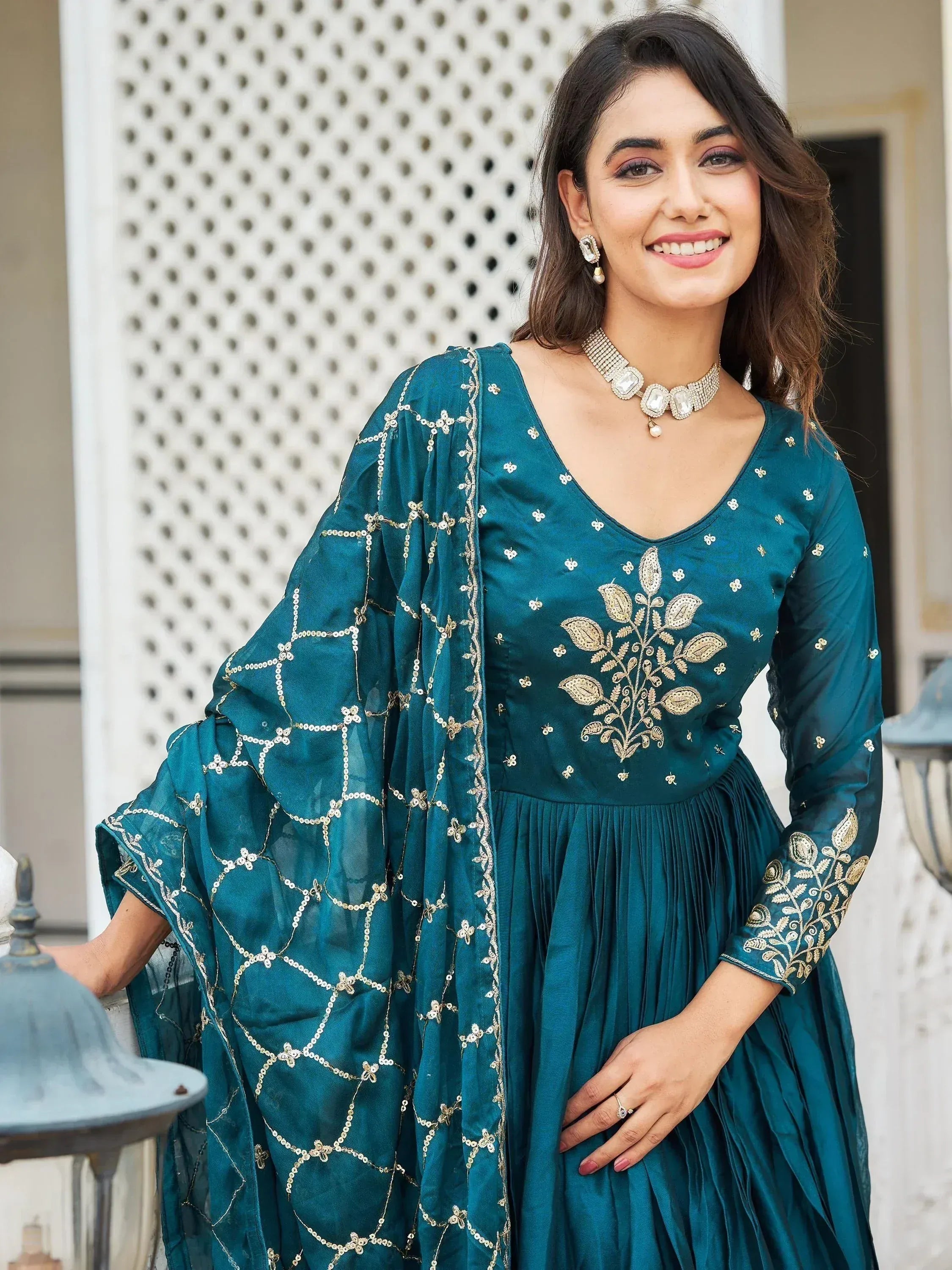 Teal ethnic gown with gold embroidery and matching dupatta, perfect for Indian celebrations