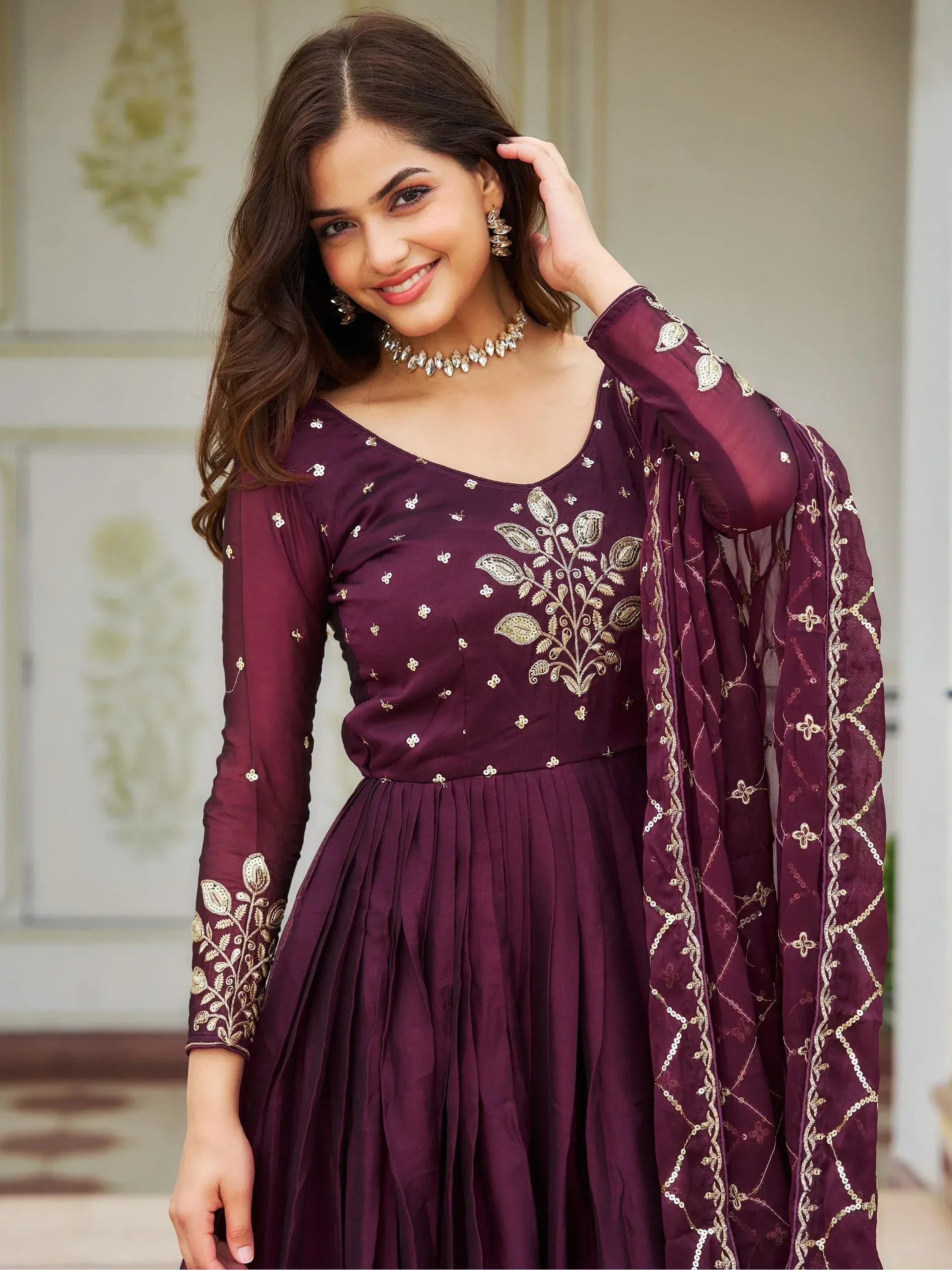 Elegant maroon ethnic gown with gold embroidery and matching dupatta, perfect for Indian occasions