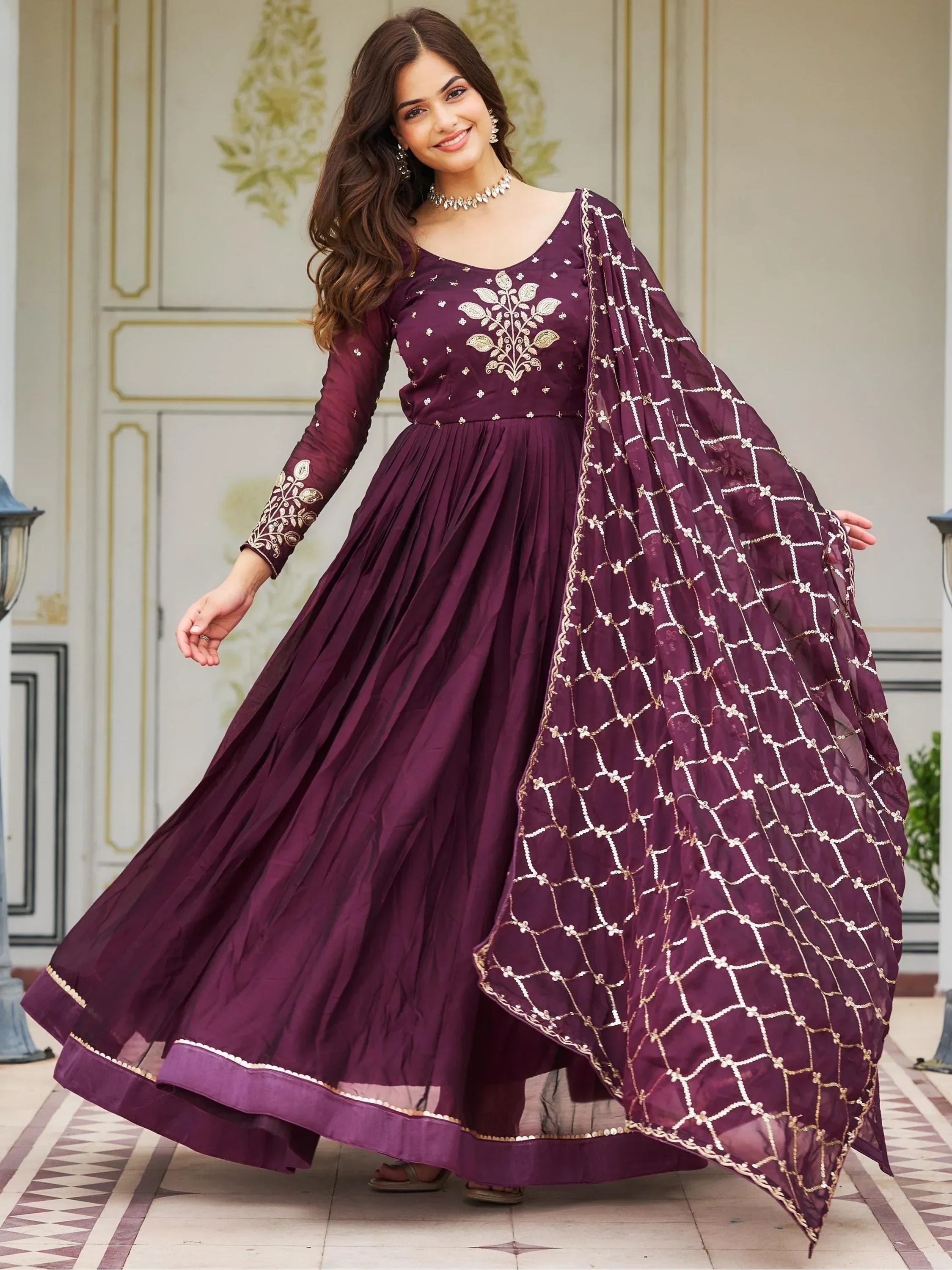 Woman in maroon embroidered ethnic gown with matching dupatta, traditional Indian wear