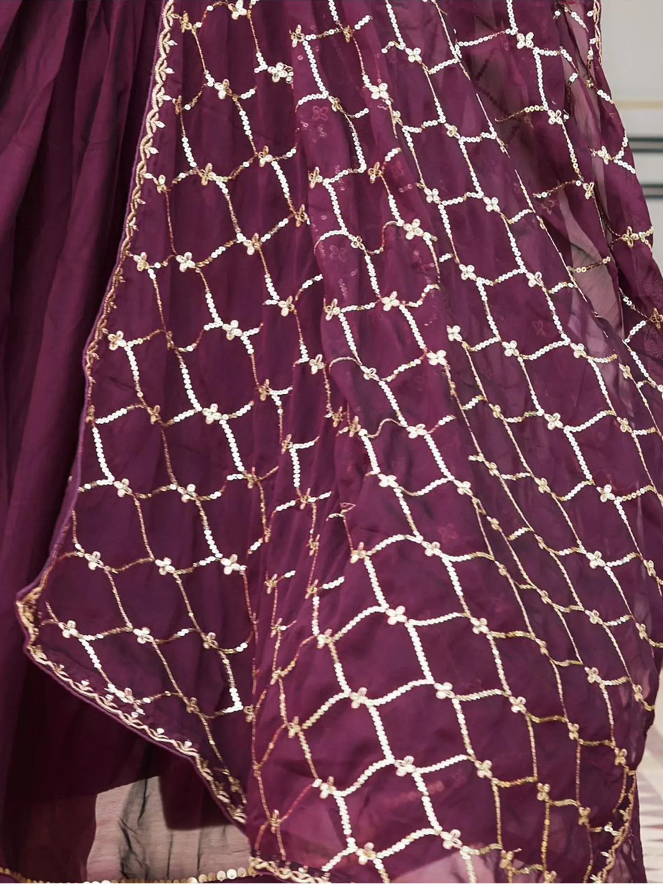 Purple ethnic gown with gold and white floral embroidery, perfect for Indian weddings and festive occasions.
