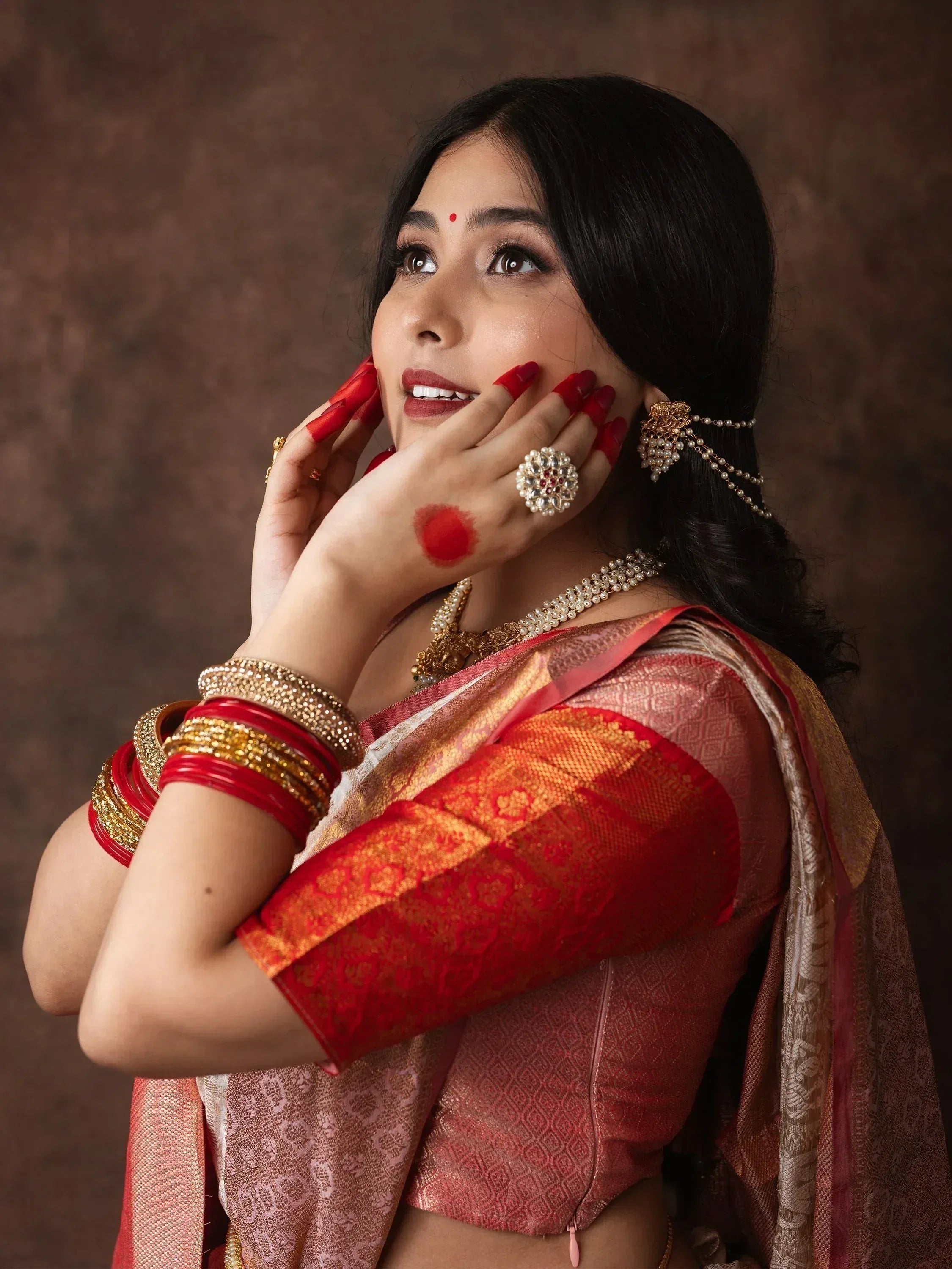 Woman in red and gold saree with traditional jewelry, perfect for Indian ethnic wear occasions