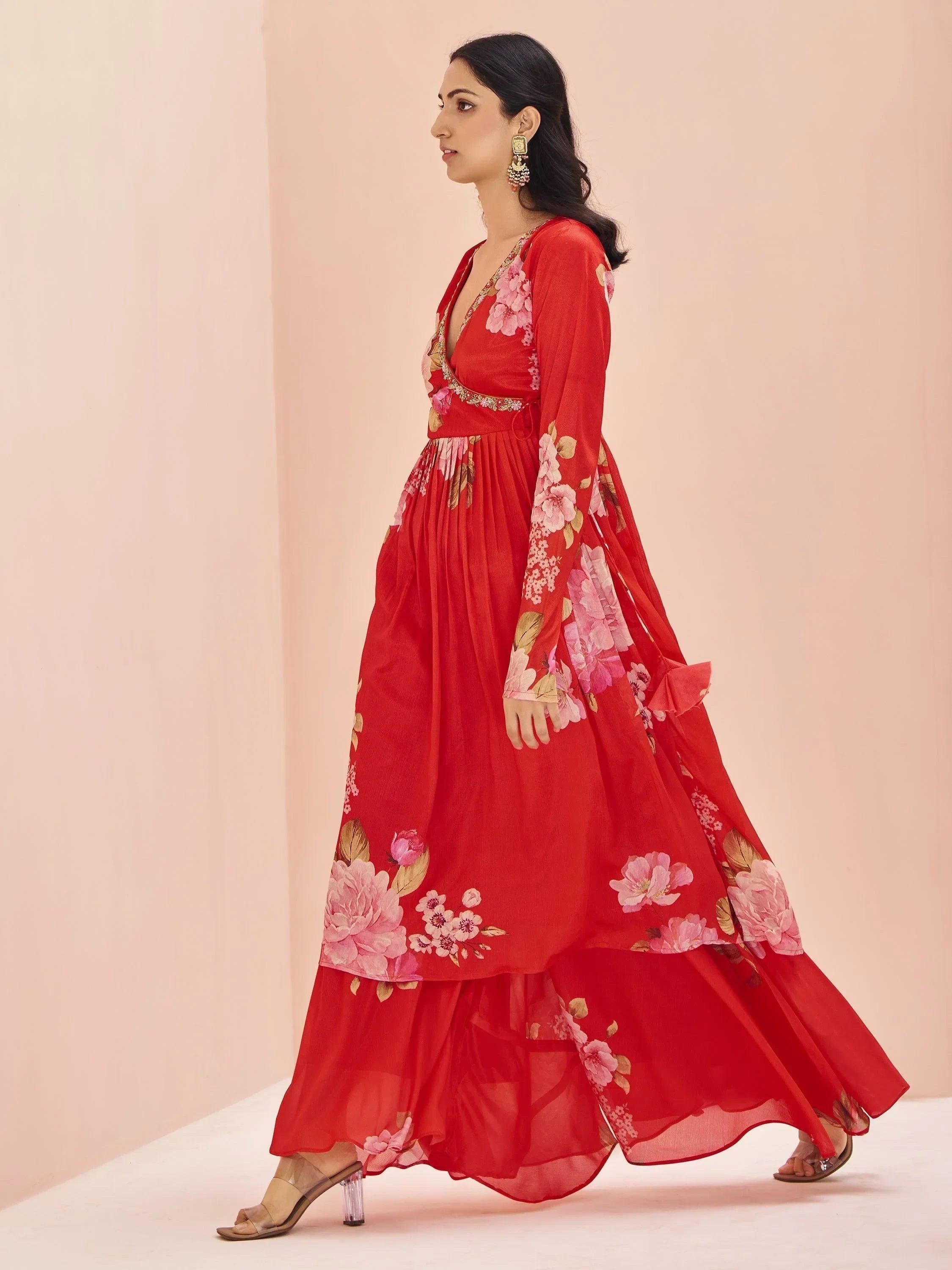 Woman wearing a red floral printed ethnic gown with long sleeves and deep neckline