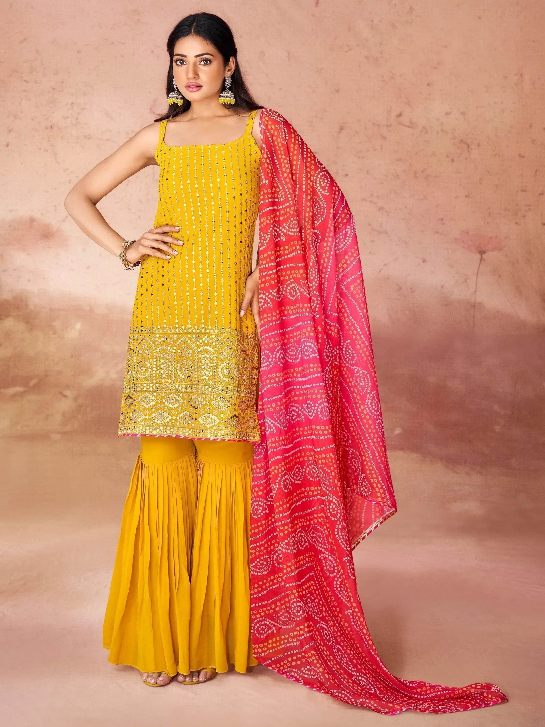 Woman in yellow sharara suit with gold detailing and pink bandhani dupatta, ethnic fashion