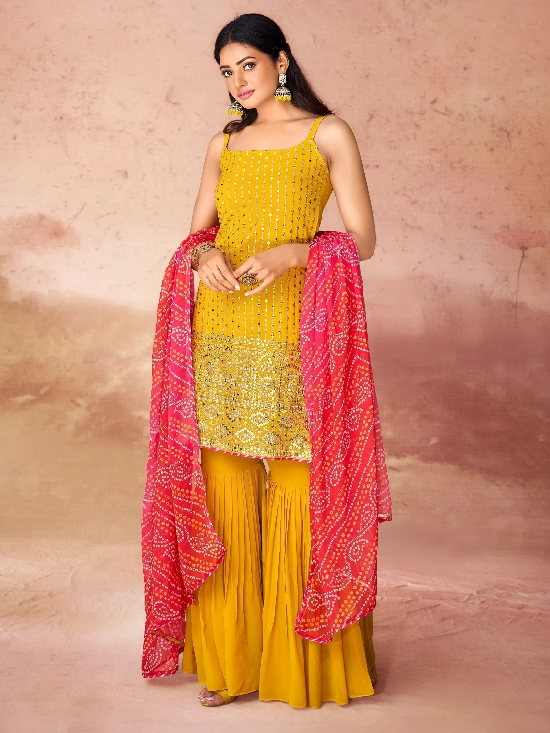 Woman in yellow sharara suit with mirror work and pink printed dupatta, ethnic wear fashion