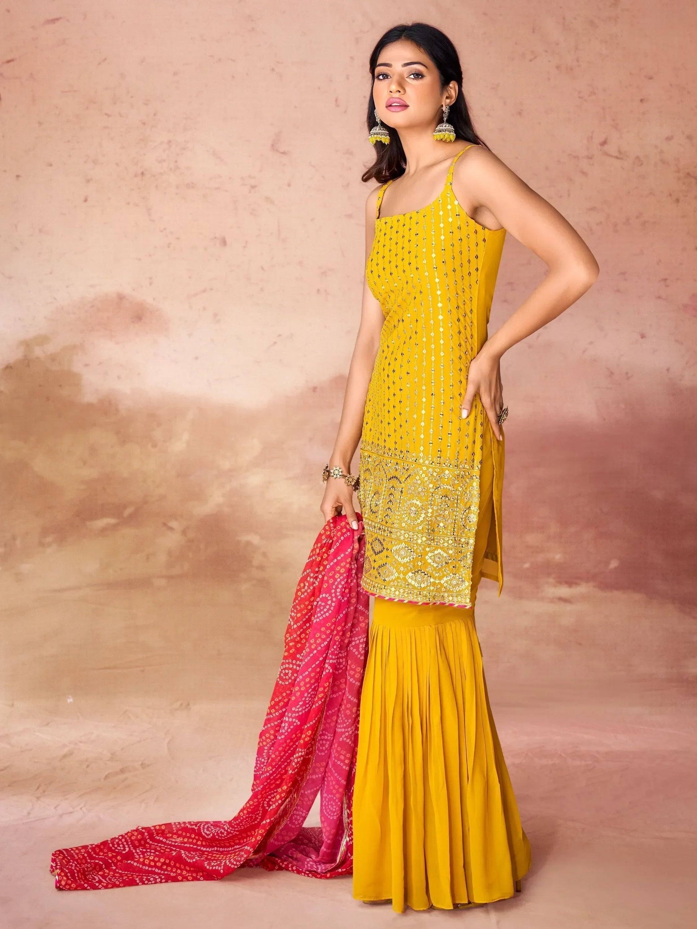 Woman in yellow embroidered sharara suit with pink dupatta, Indian ethnic wear fashion