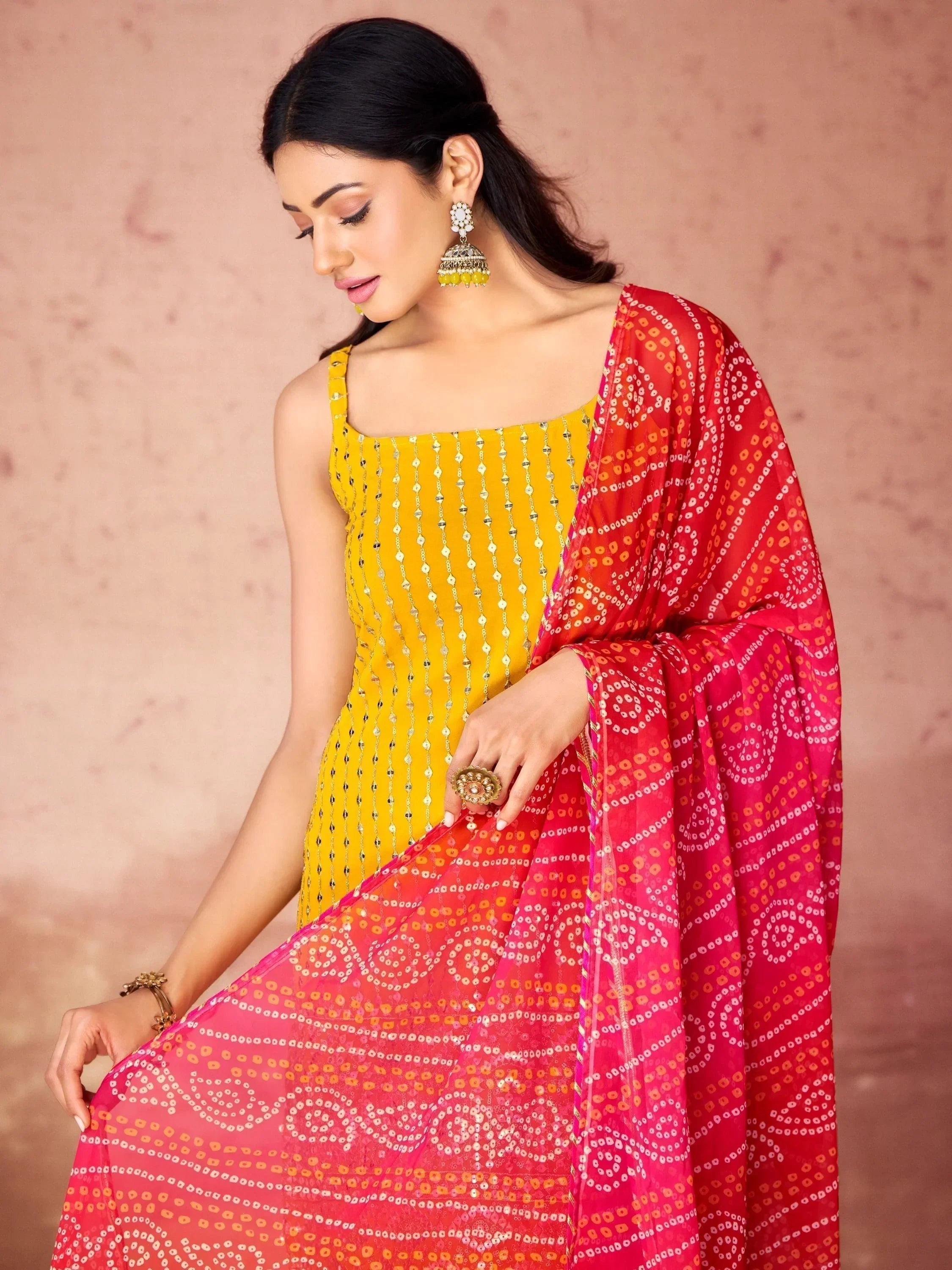 Woman in yellow bandhani salwar kameez with pink dupatta, traditional Indian ethnic wear