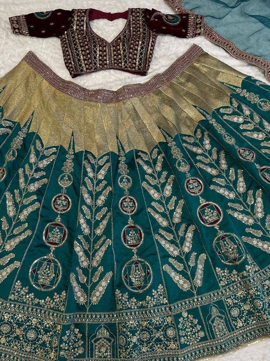 Teal and gold embroidered lehenga choli with intricate mirror work and floral motifs, perfect for Indian weddings.