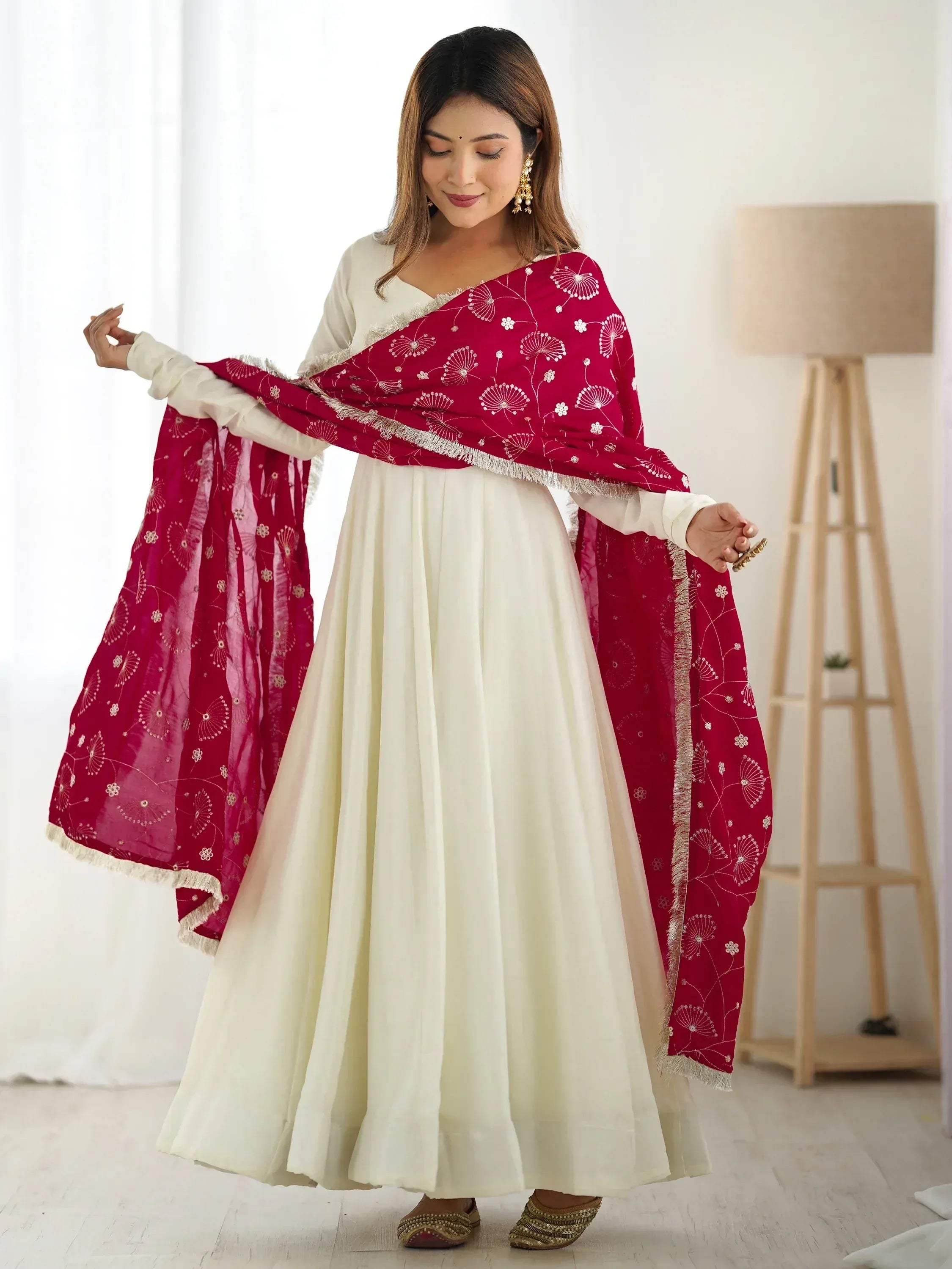 Woman in cream ethnic gown with red embroidered dupatta, traditional Indian attire