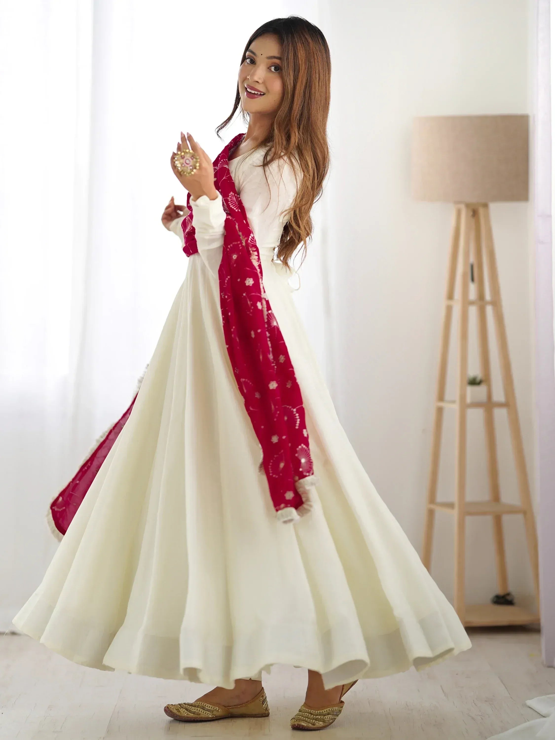 Woman in white ethnic gown with red dupatta, traditional Indian wear, indoor setting