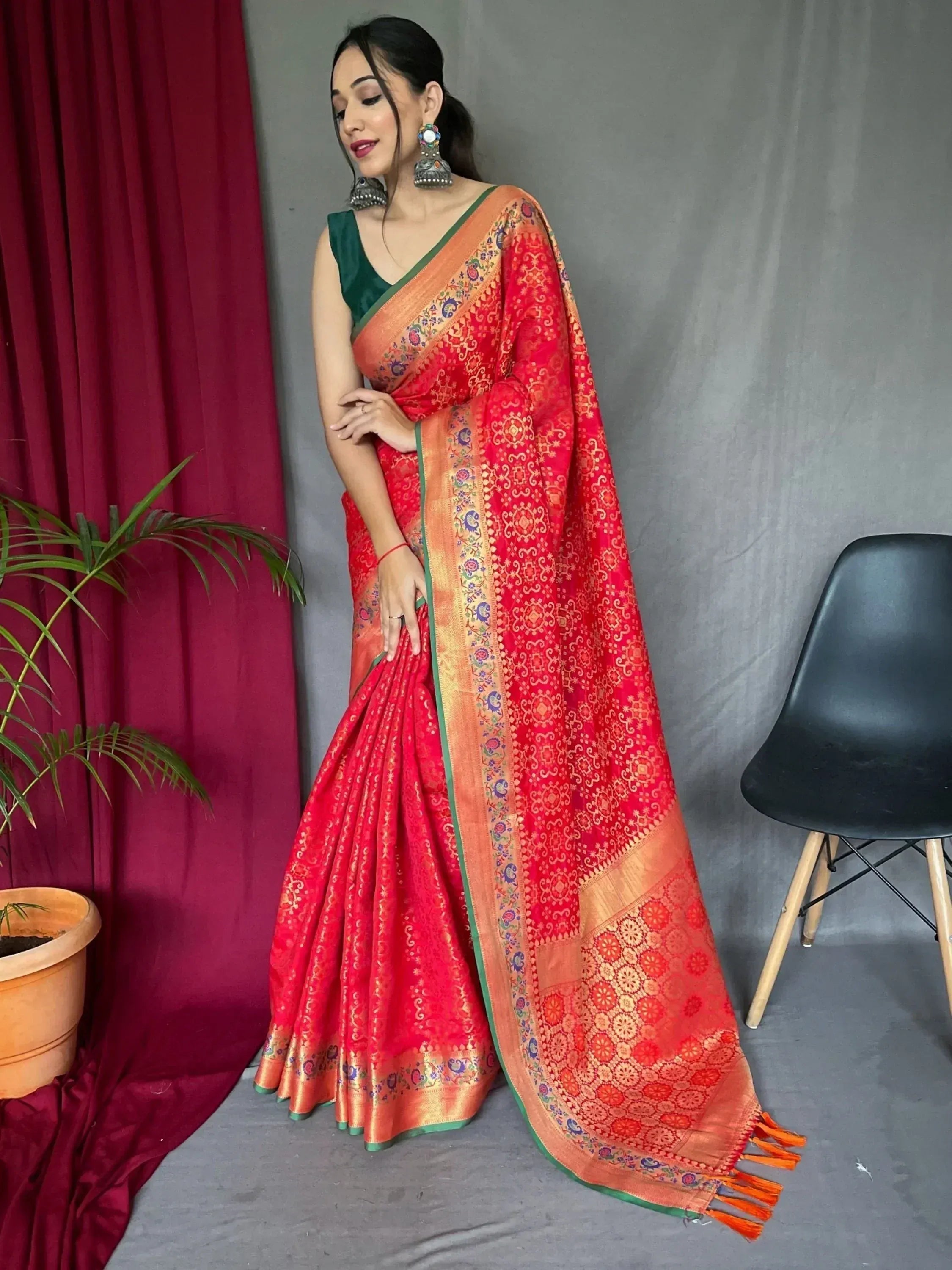 Red and gold designer saree with intricate patterns, paired with green blouse, perfect for Indian ethnic wear