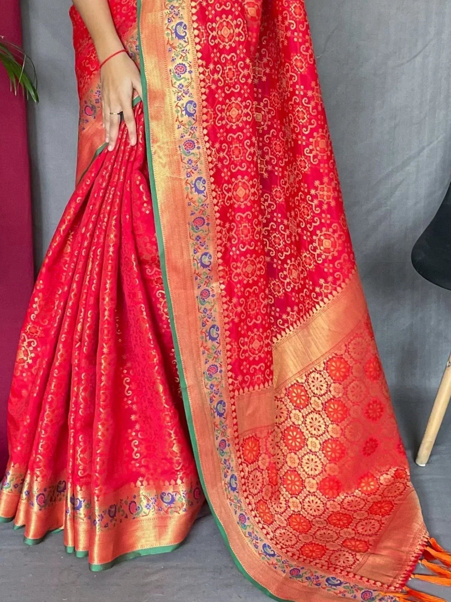 Red designer saree with gold floral motifs and colorful border, ethnic Indian wear