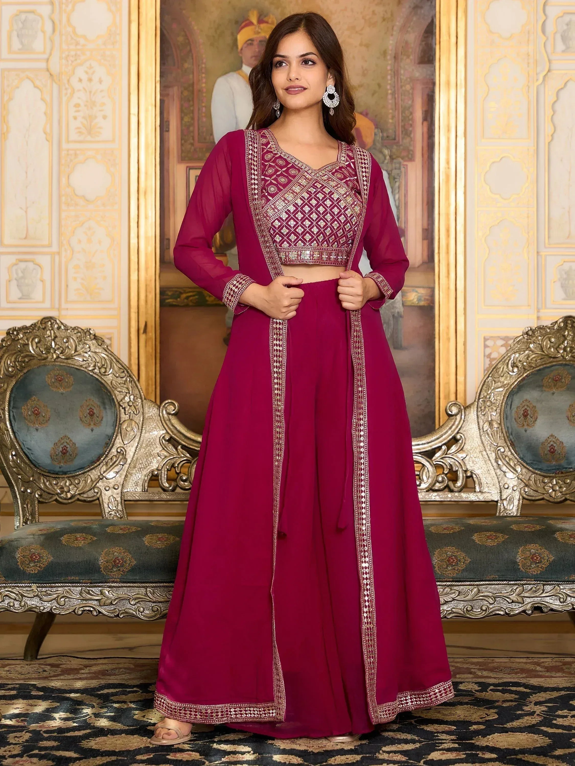 Woman in magenta embroidered lehenga choli with dupatta in ornate room