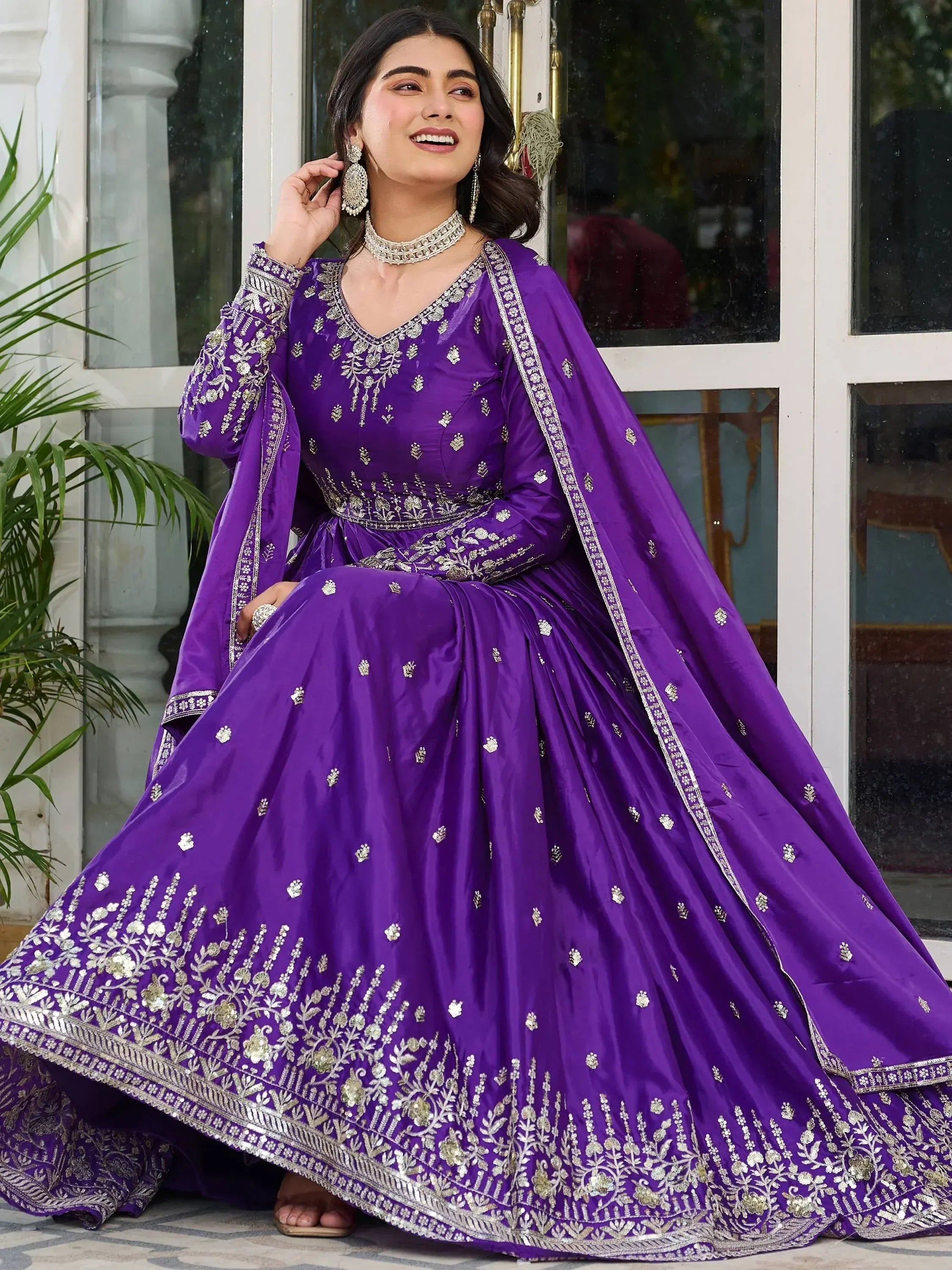 Woman wearing a purple lehenga choli with gold embroidery, traditional Indian ethnic wear