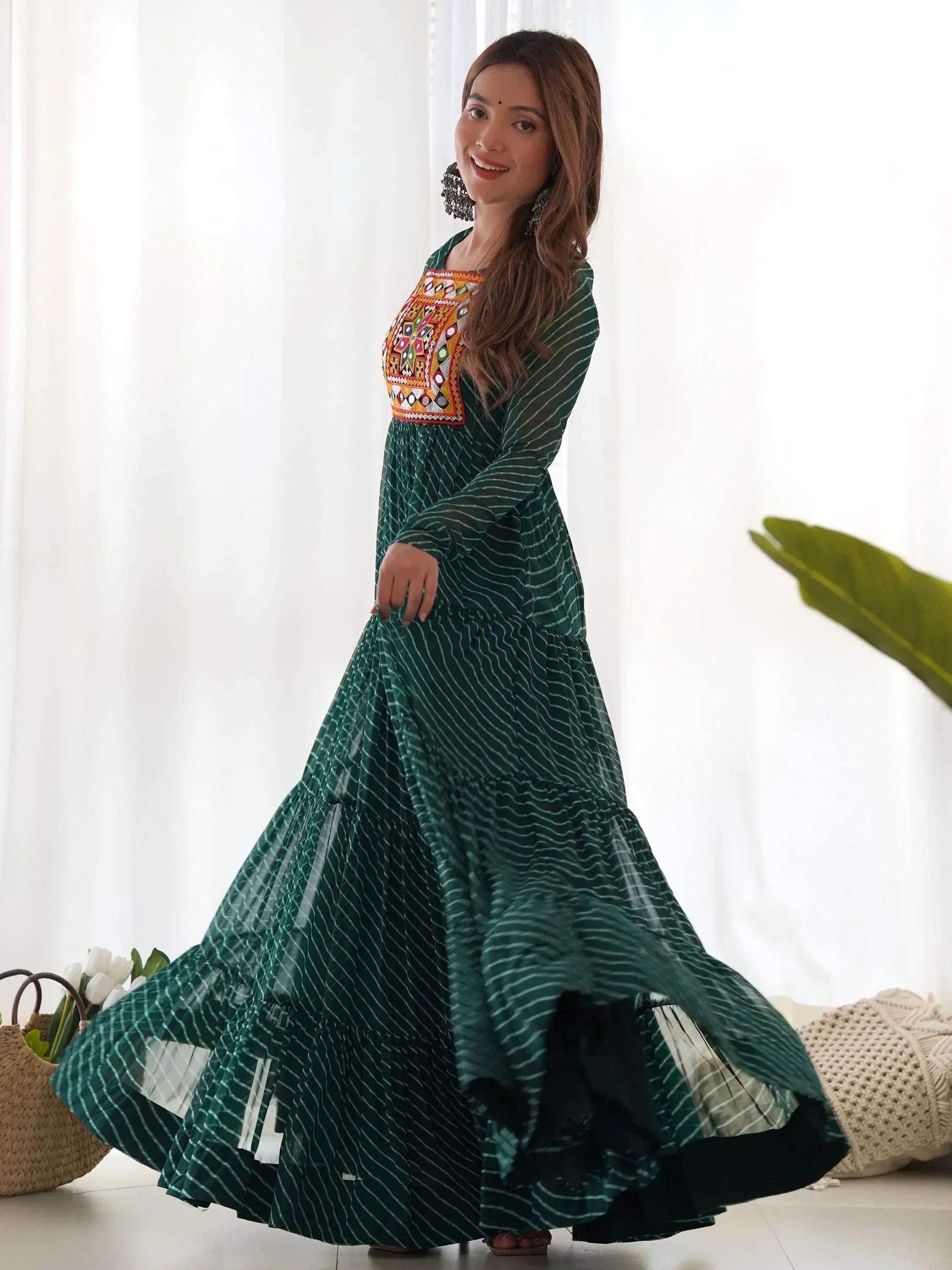 Woman in green striped ethnic gown with colorful embroidery, perfect for Indian occasions and festive wear.