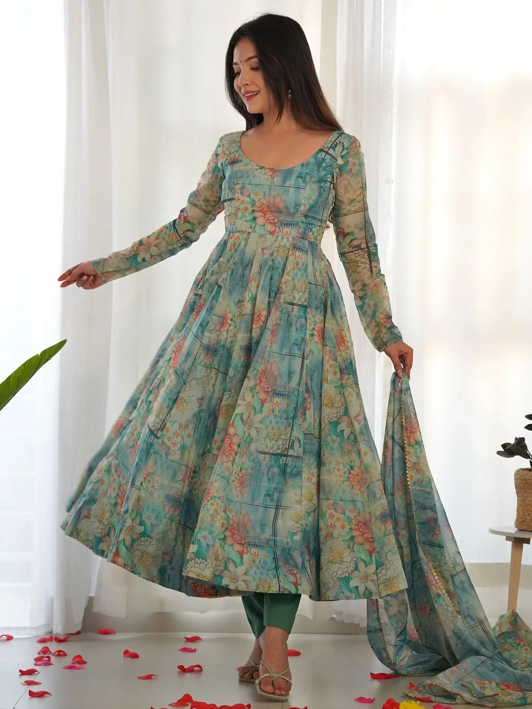 Floral print ethnic gown with long sleeves, paired with green pants and dupatta, perfect for Indian occasions.