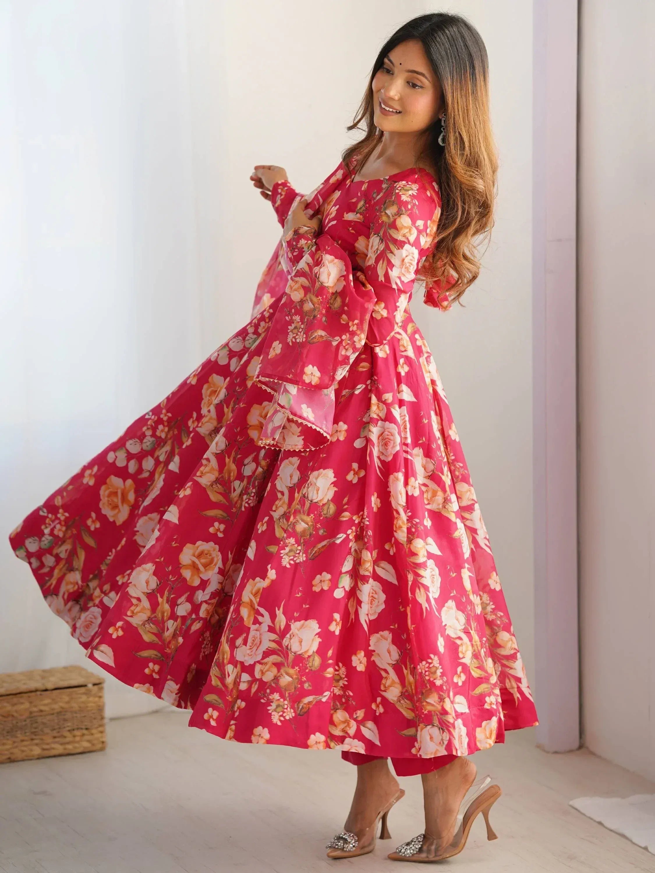 Woman in pink floral ethnic gown with flared sleeves, perfect for Indian occasions and festive wear