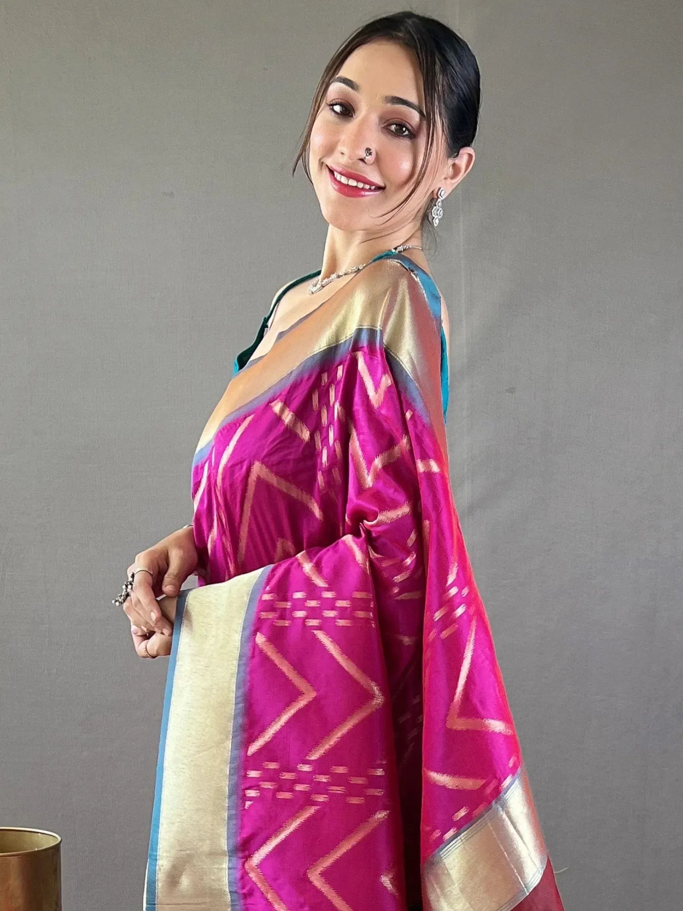 Woman in vibrant pink and gold ethnic saree with geometric patterns, perfect for Indian occasions