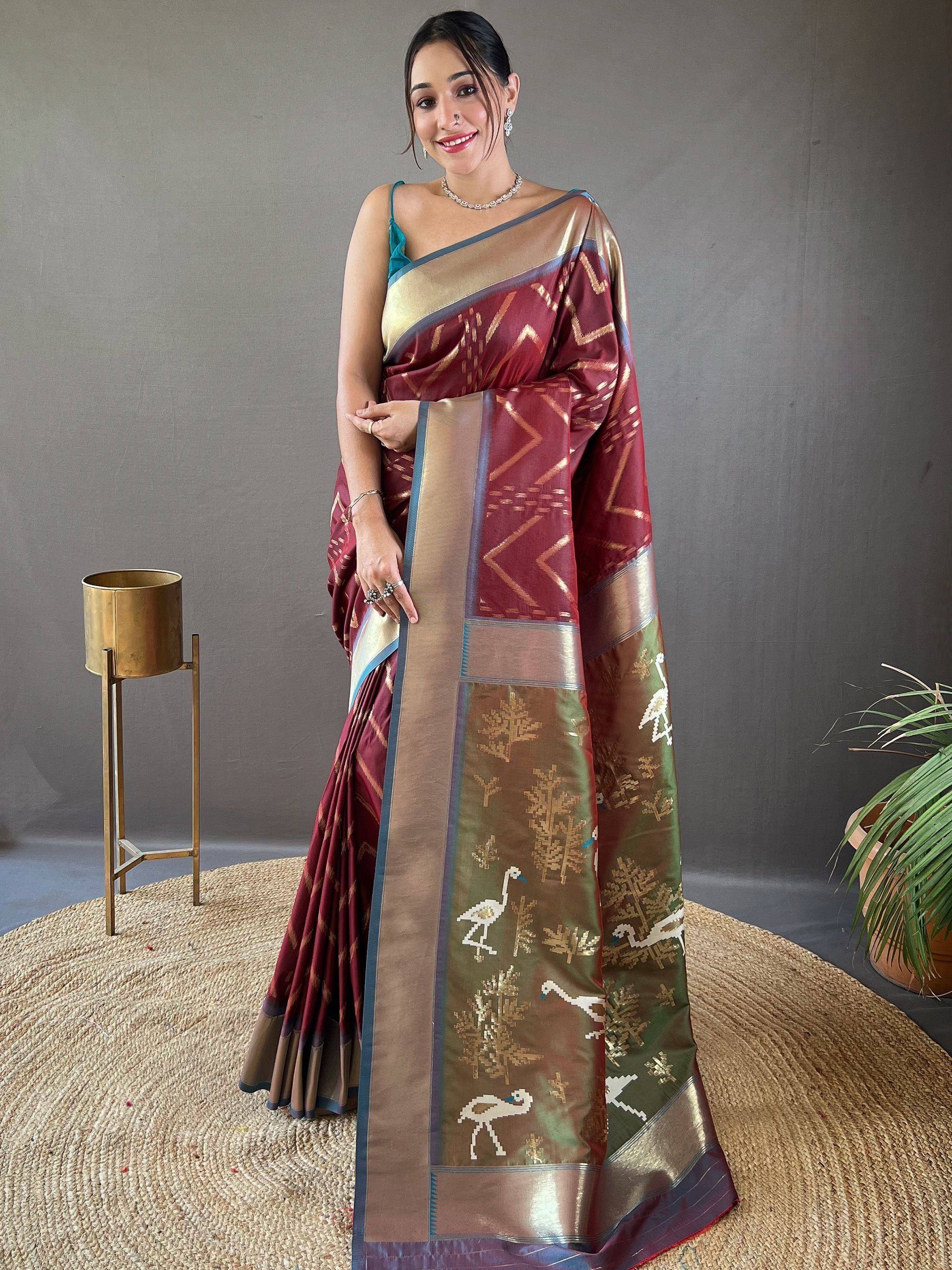 Woman in maroon and gold ethnic saree with bird and tree motifs, perfect for Indian occasions