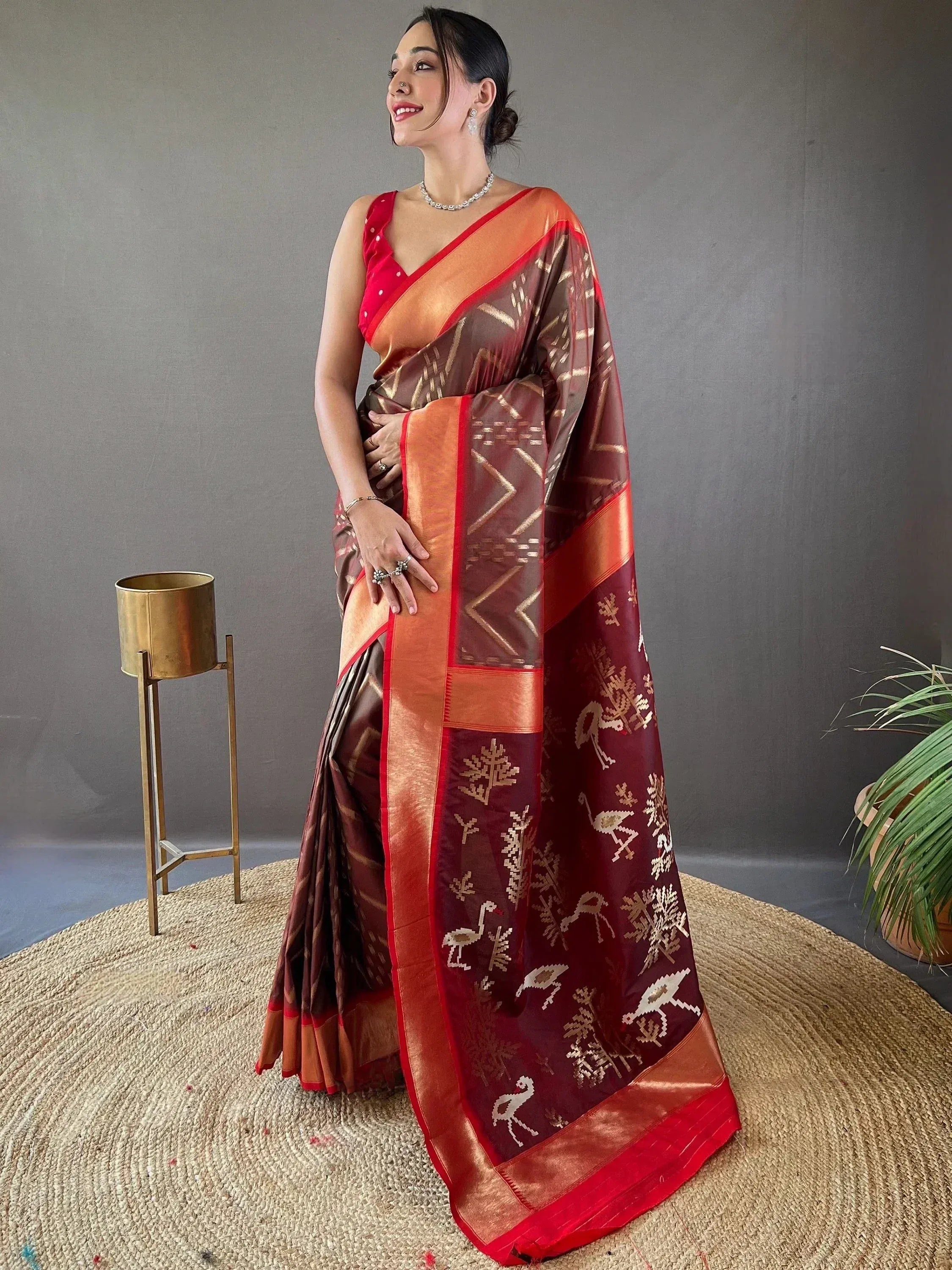 Woman in maroon and orange ethnic saree with bird motifs, perfect for Indian occasions