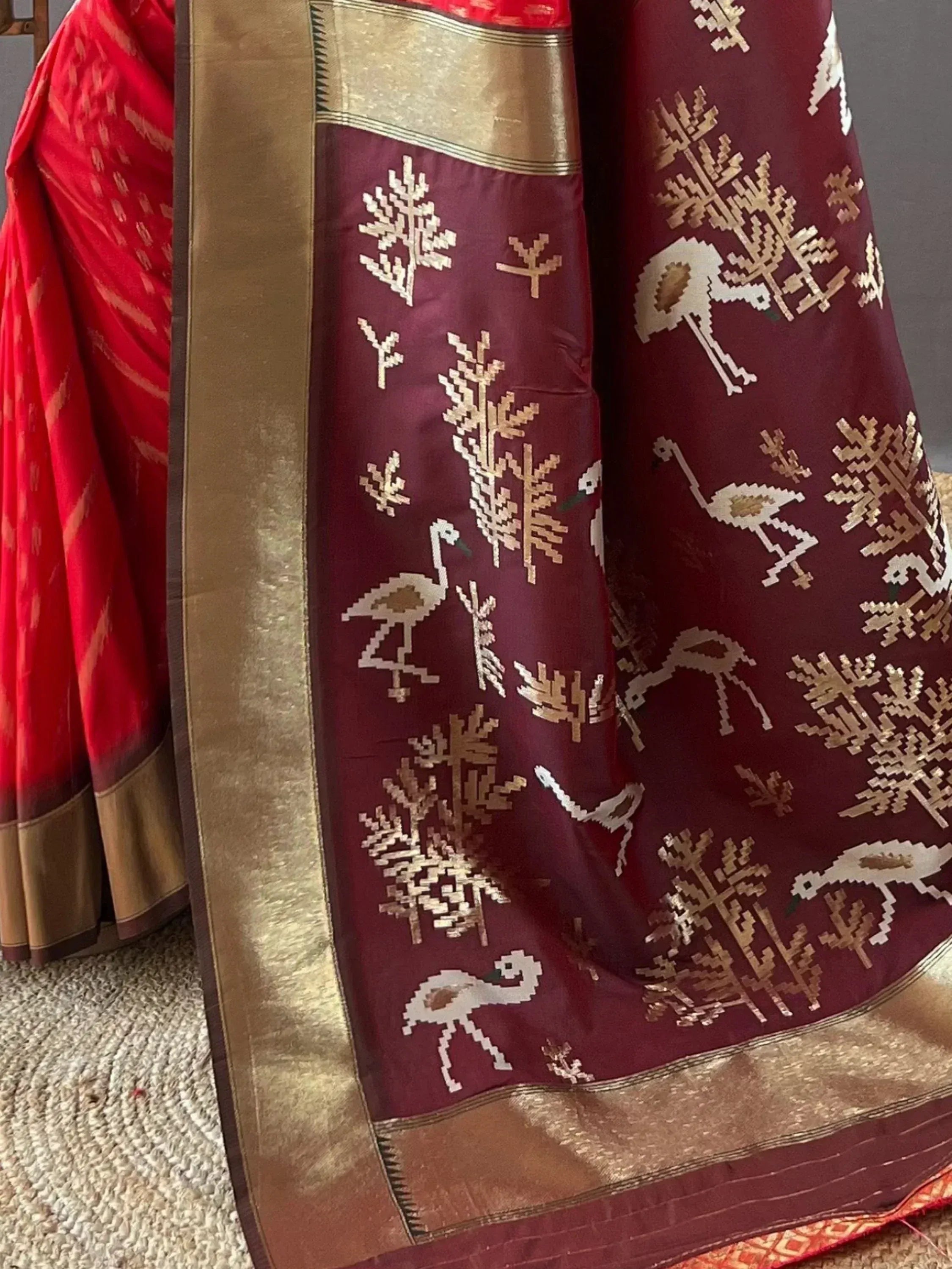 Maroon and red ethnic saree with golden bird and tree motifs, traditional Indian designer wear